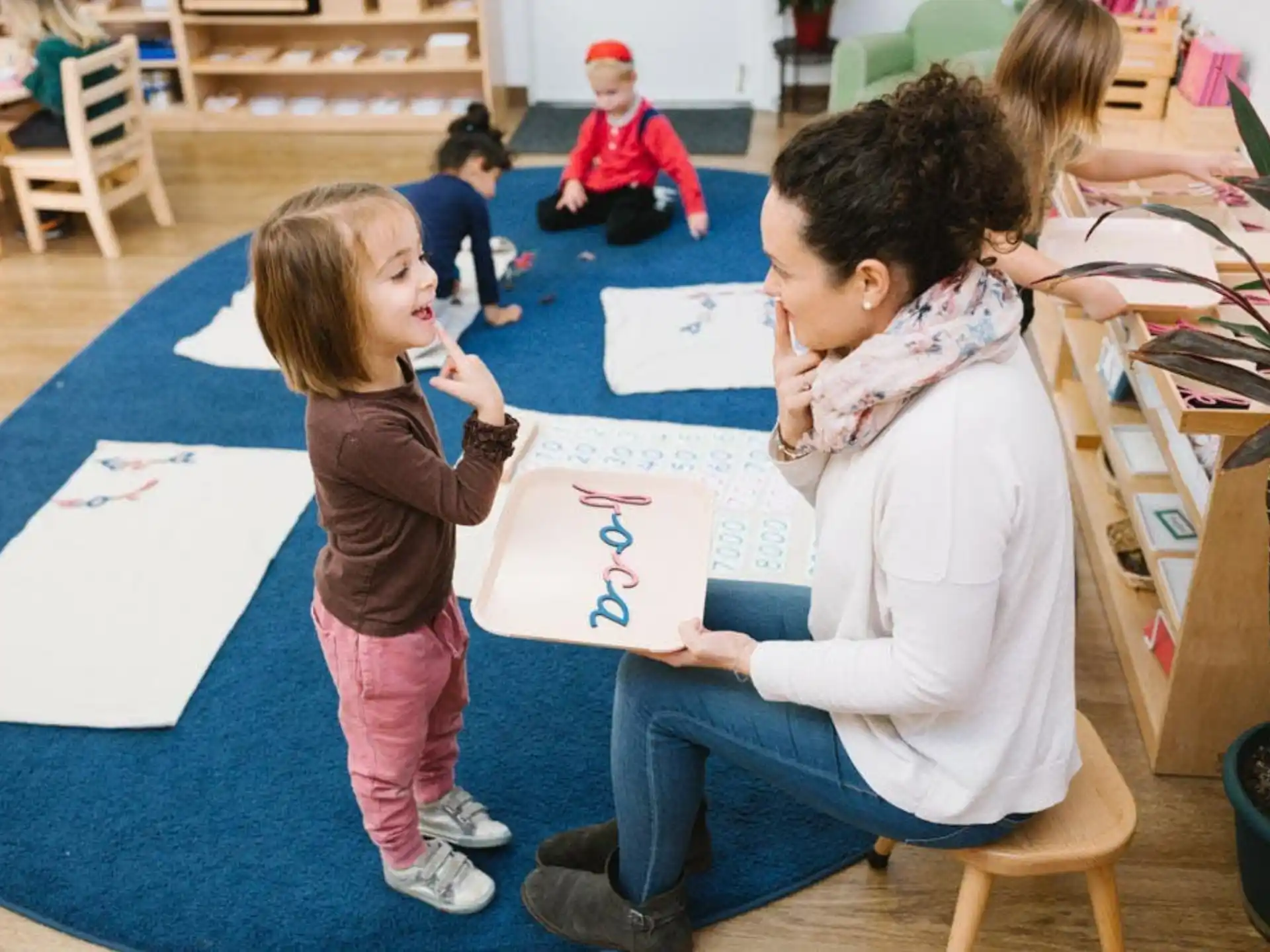 a group of children sitting on the floor and looking at a paper
