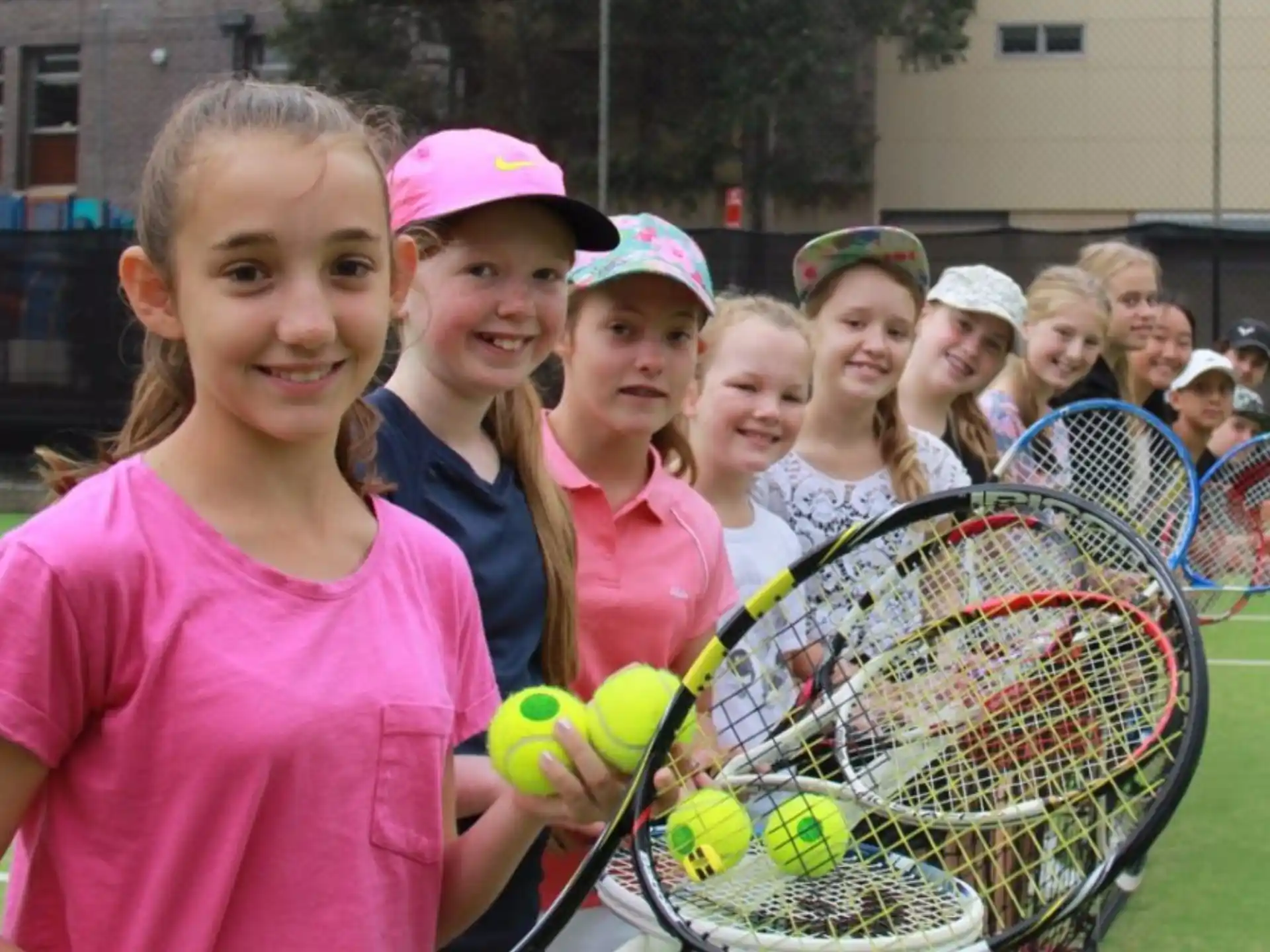 a group of girls holding tennis rackets