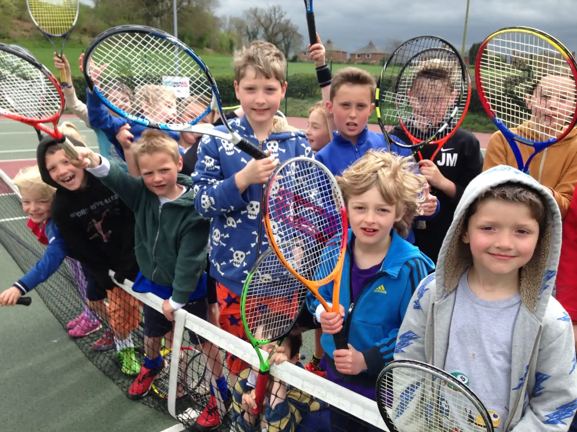 a group of kids holding tennis rackets