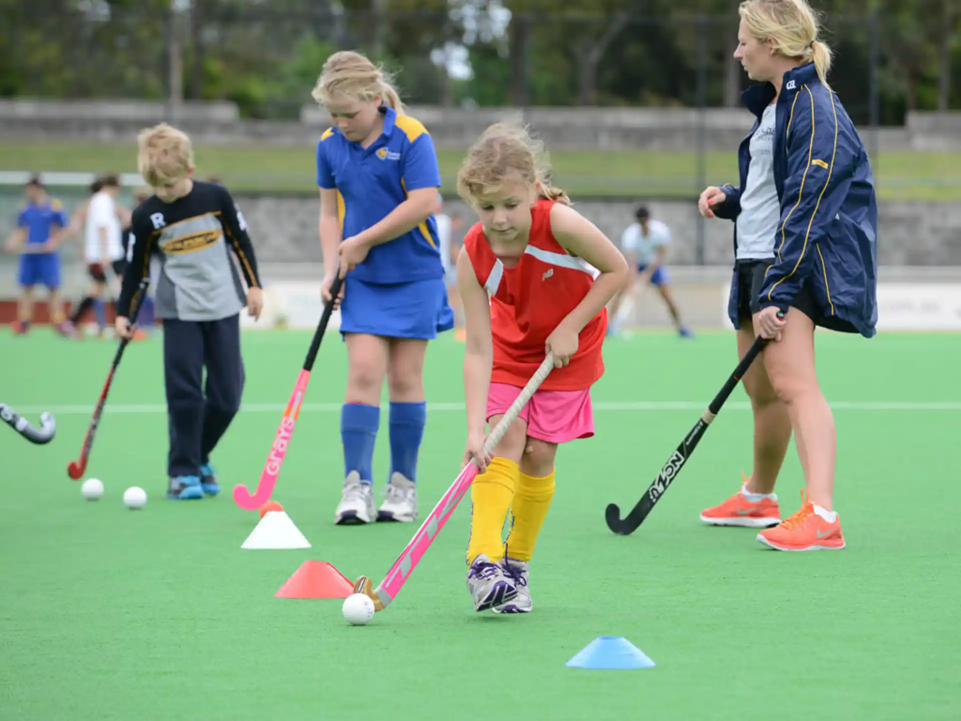 a group of girls playing field hockey