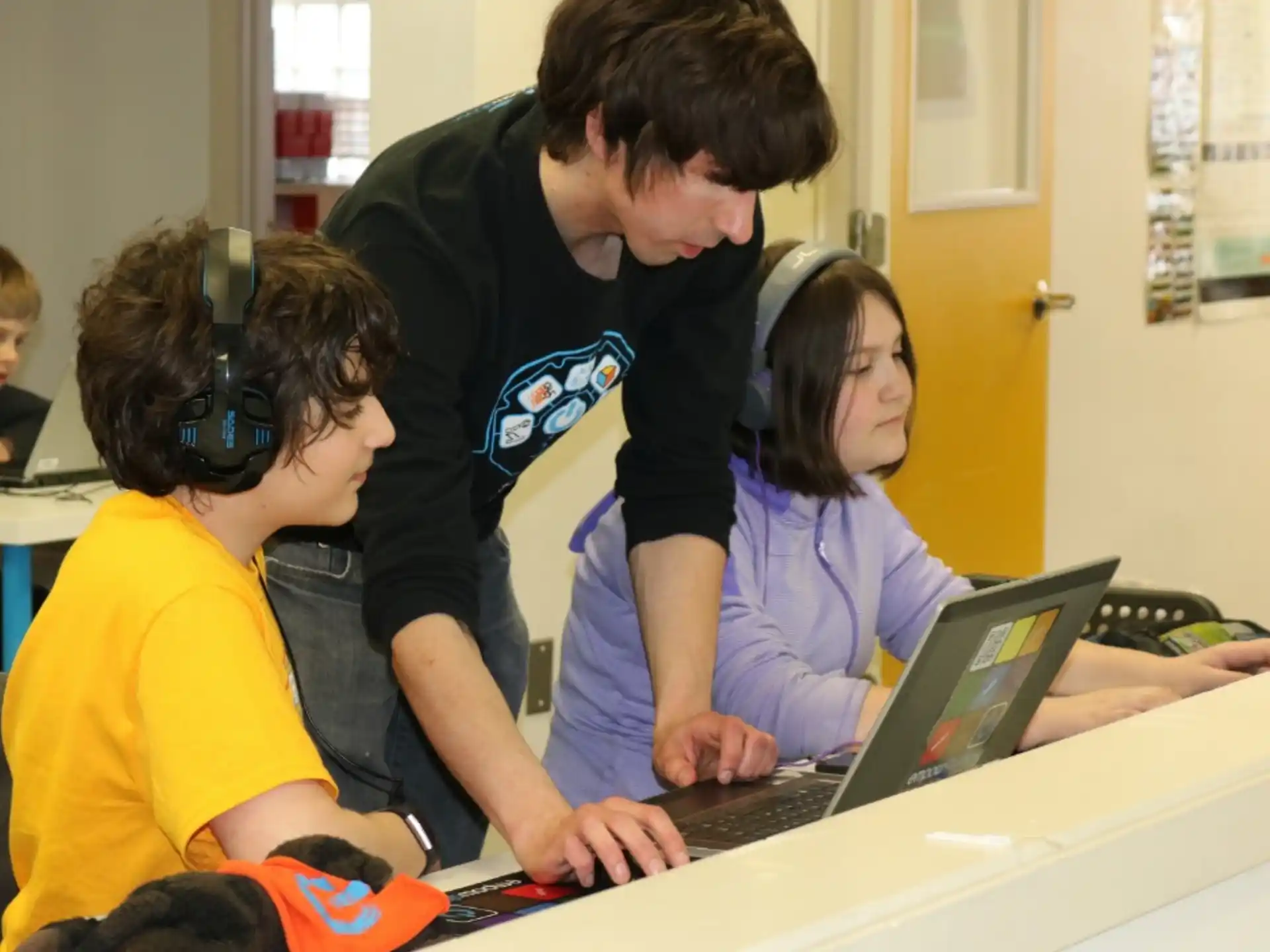 a group of people looking at a laptop