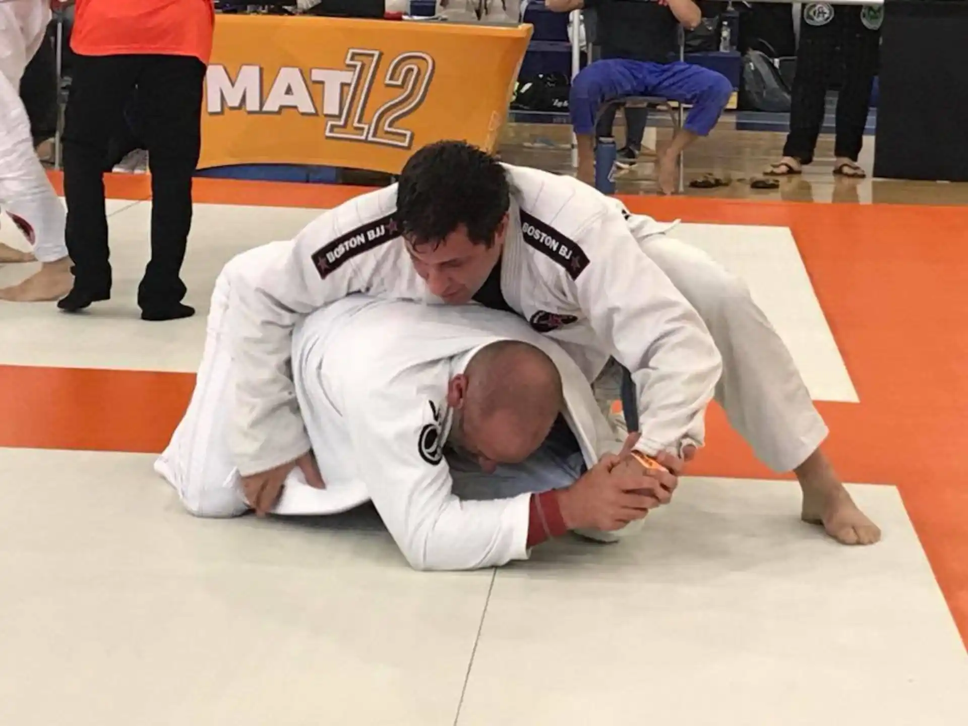 a man in white karate uniform holding another man in a white uniform