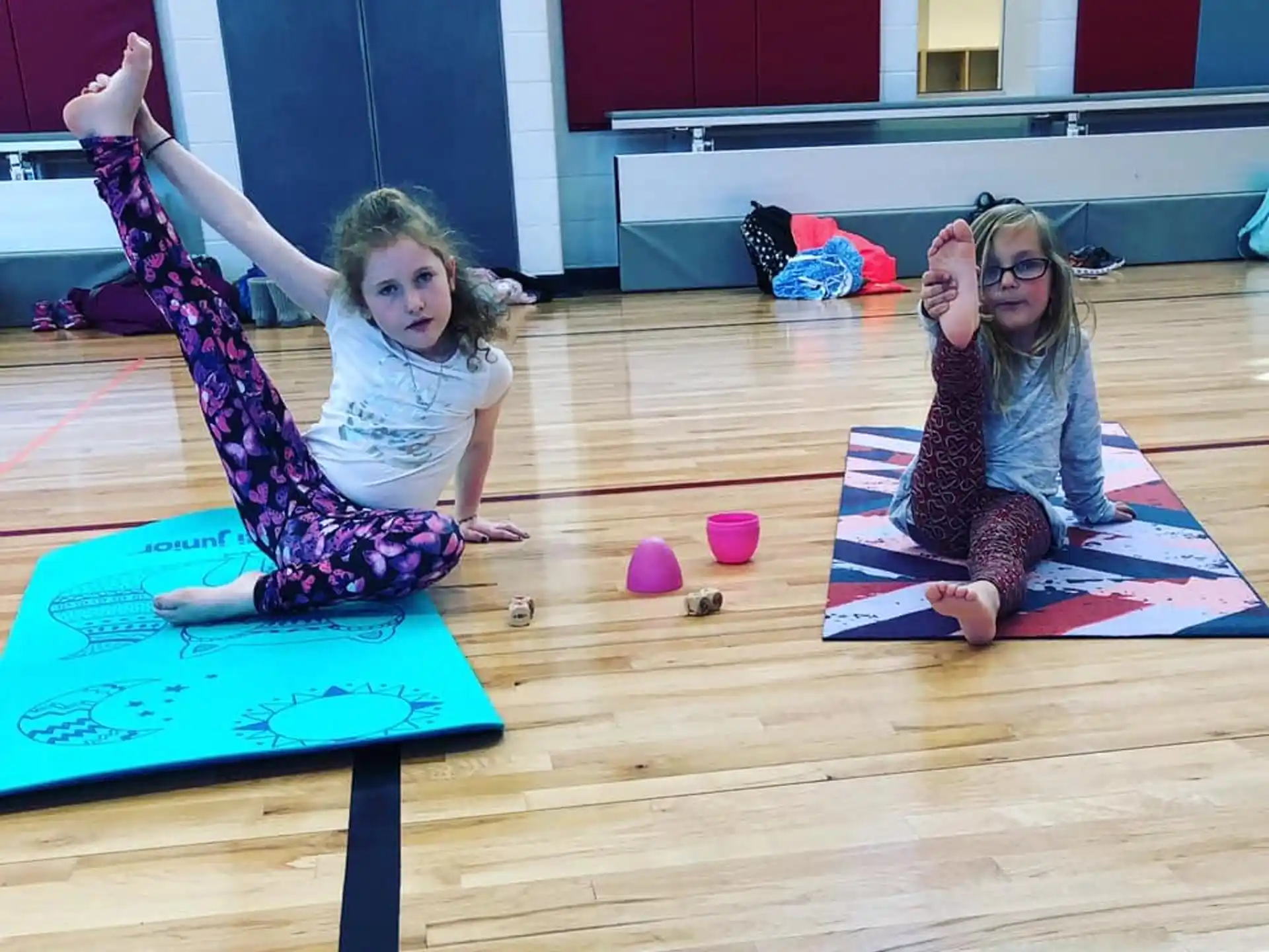 two girls sitting on mats