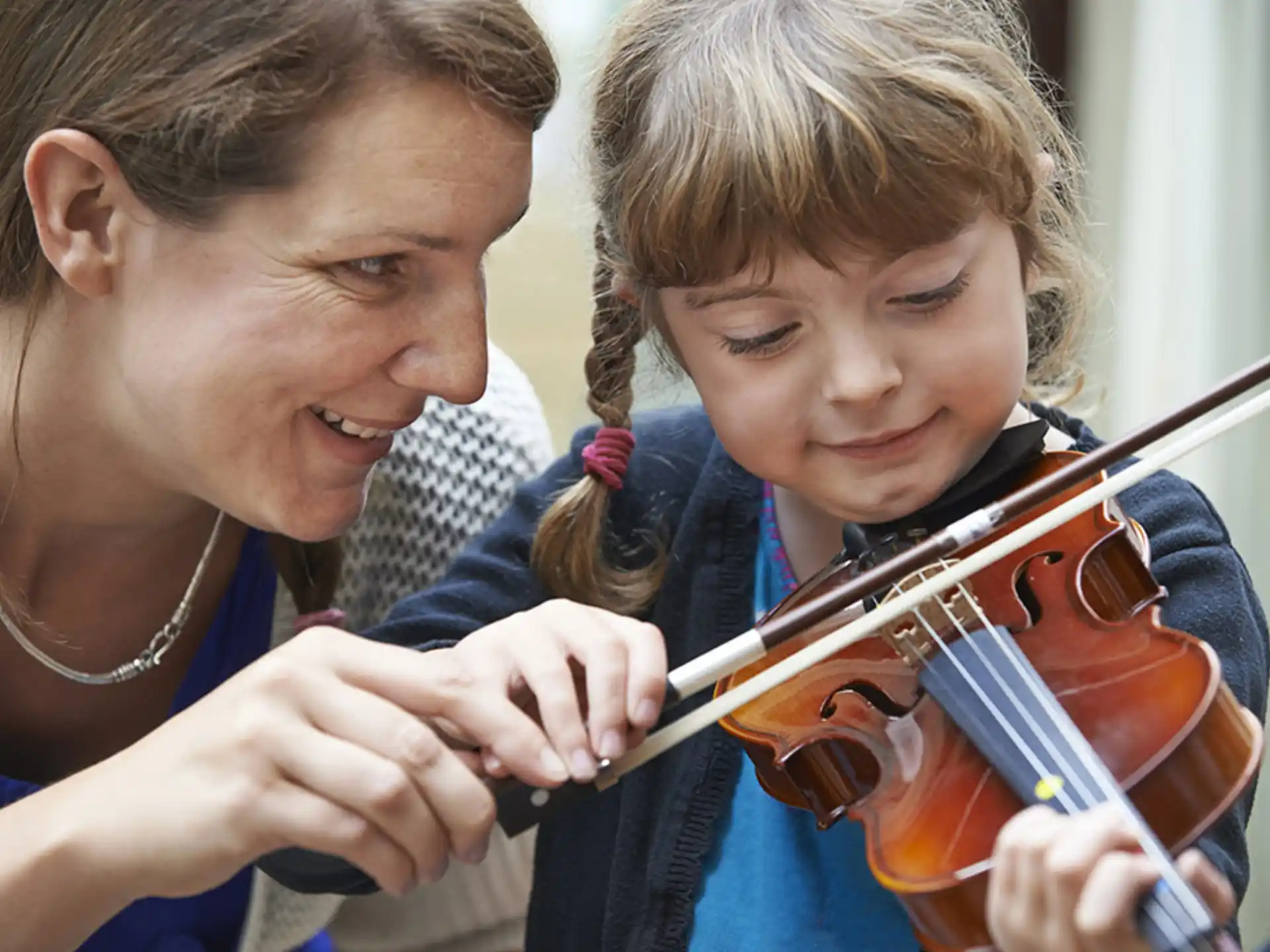 a person and a child playing violin