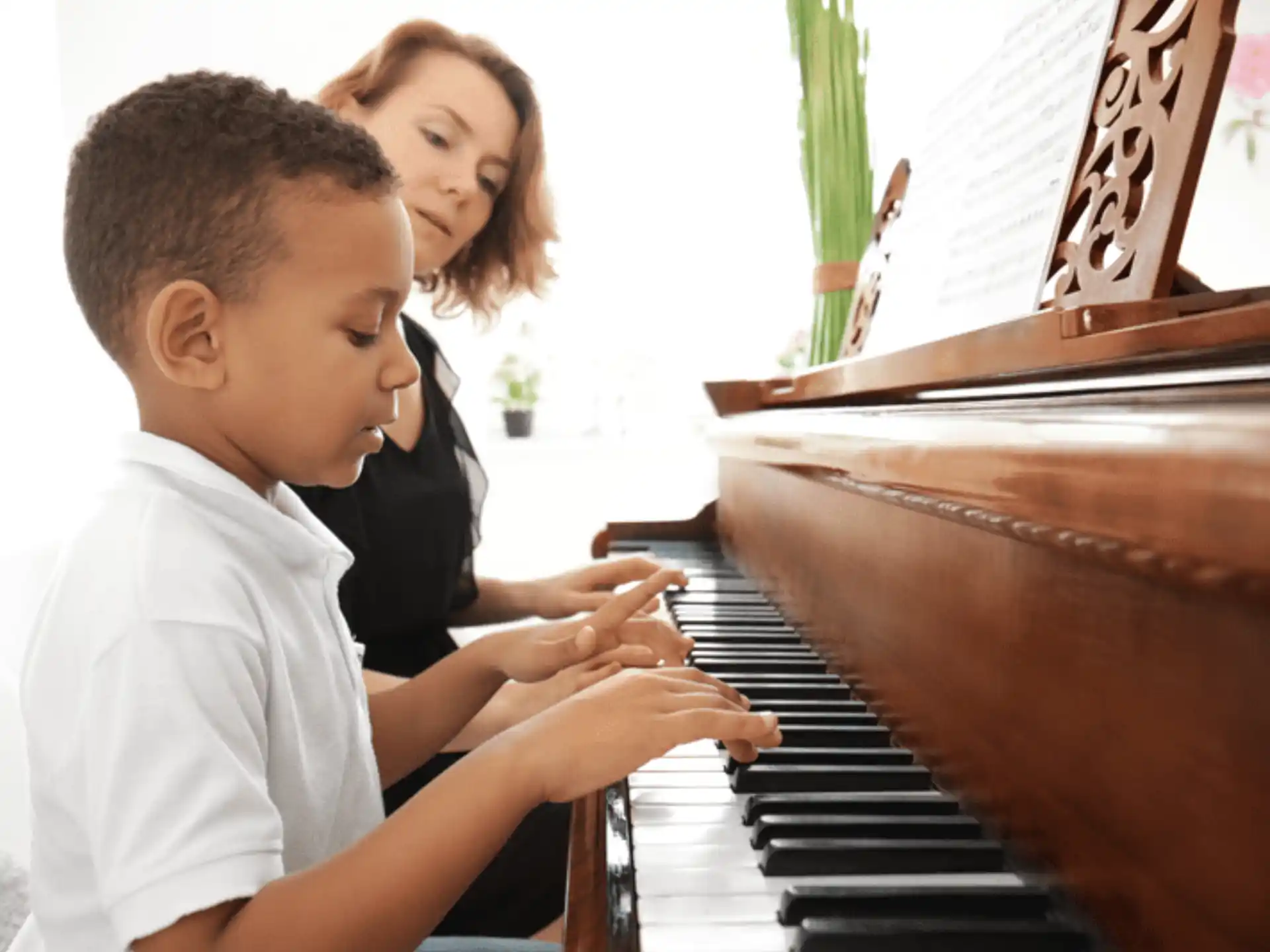 a person and a boy playing a piano