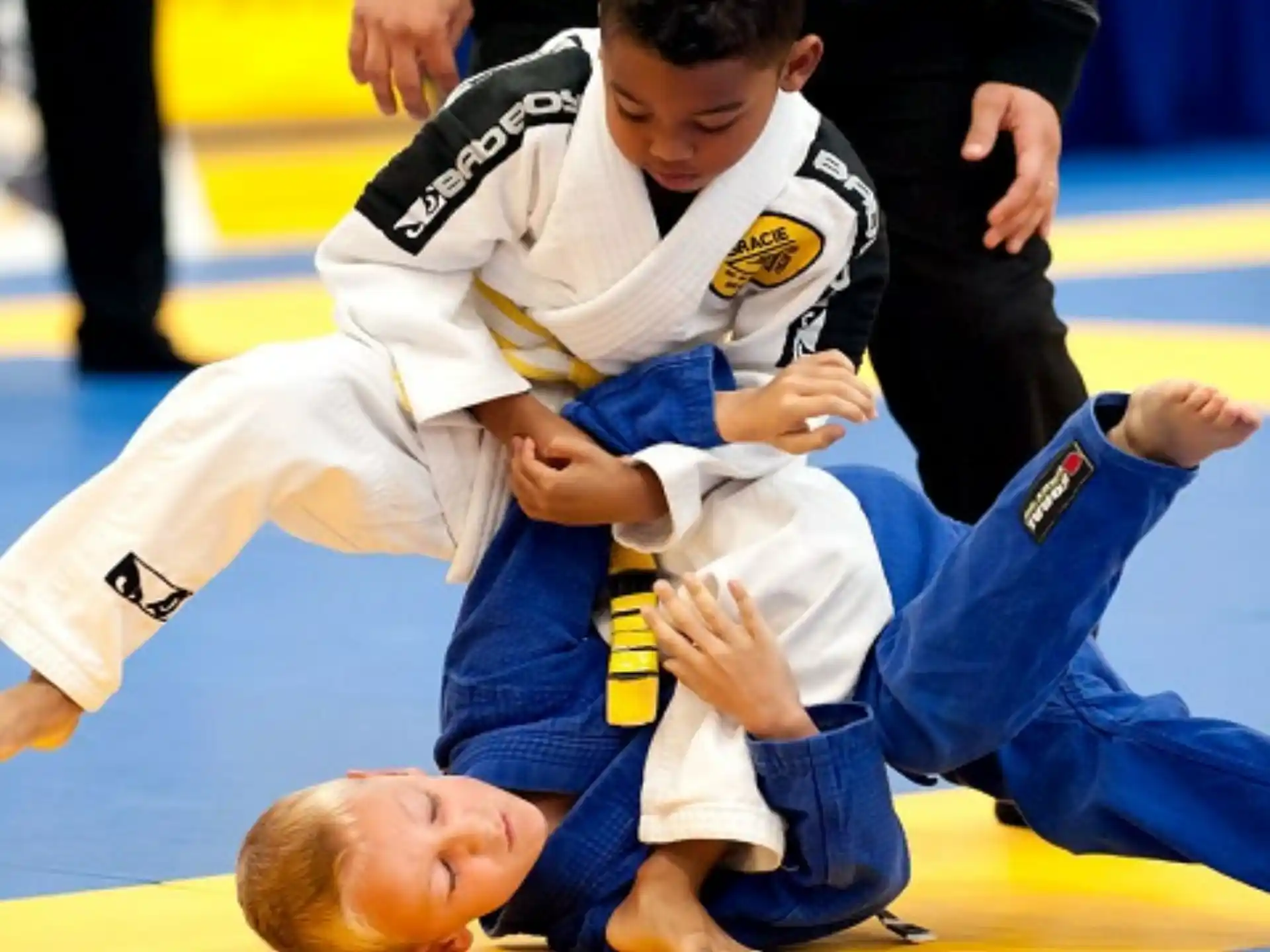 a person in a karate uniform kicking another man in the face