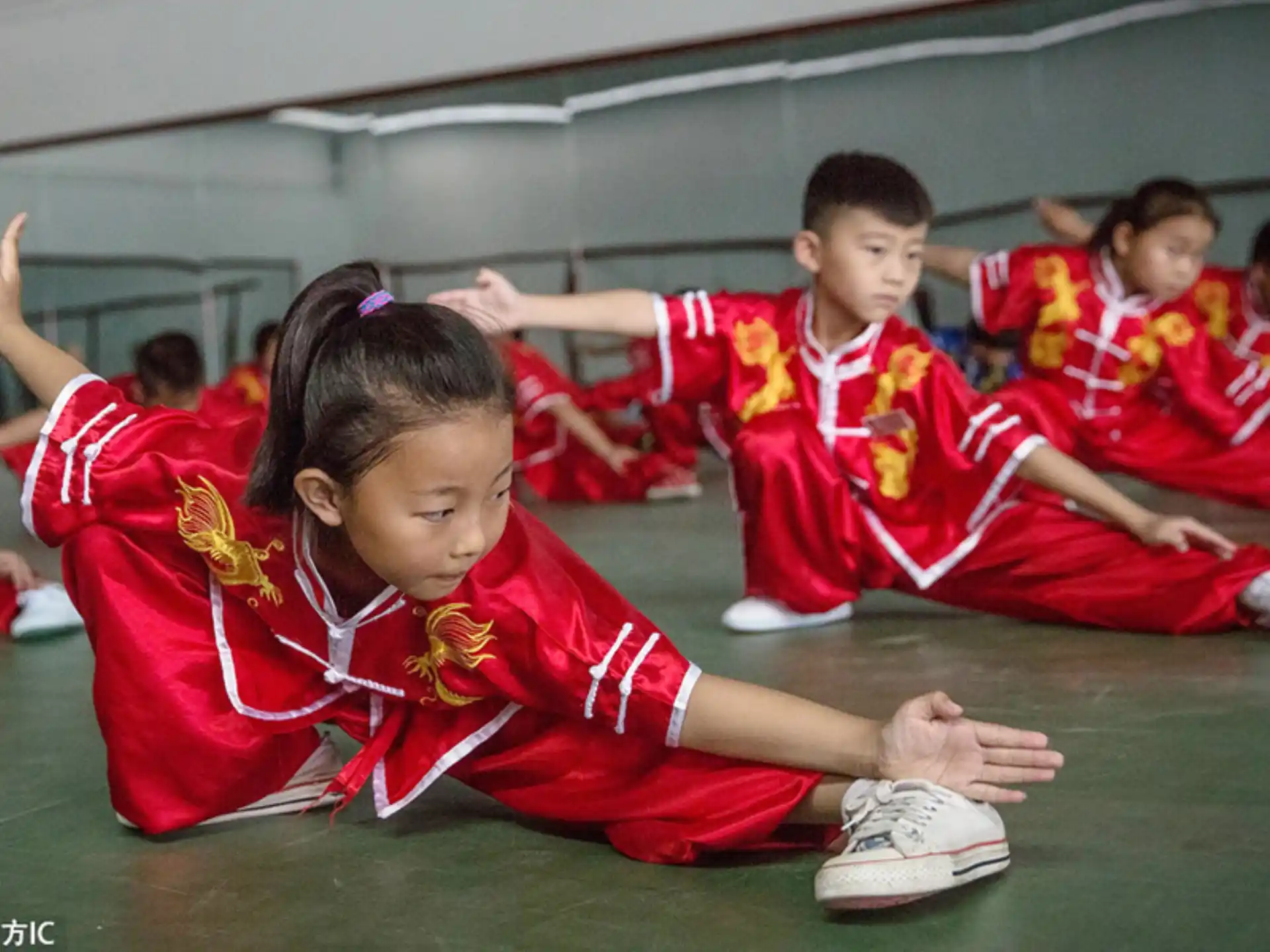 a group of children in red uniforms