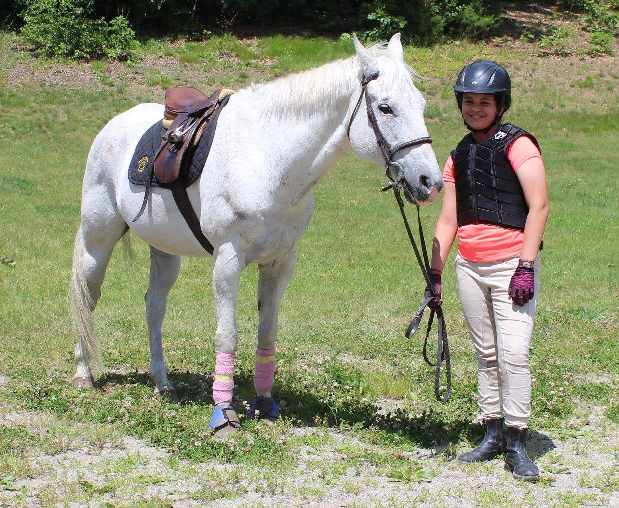 a person standing next to a white horse