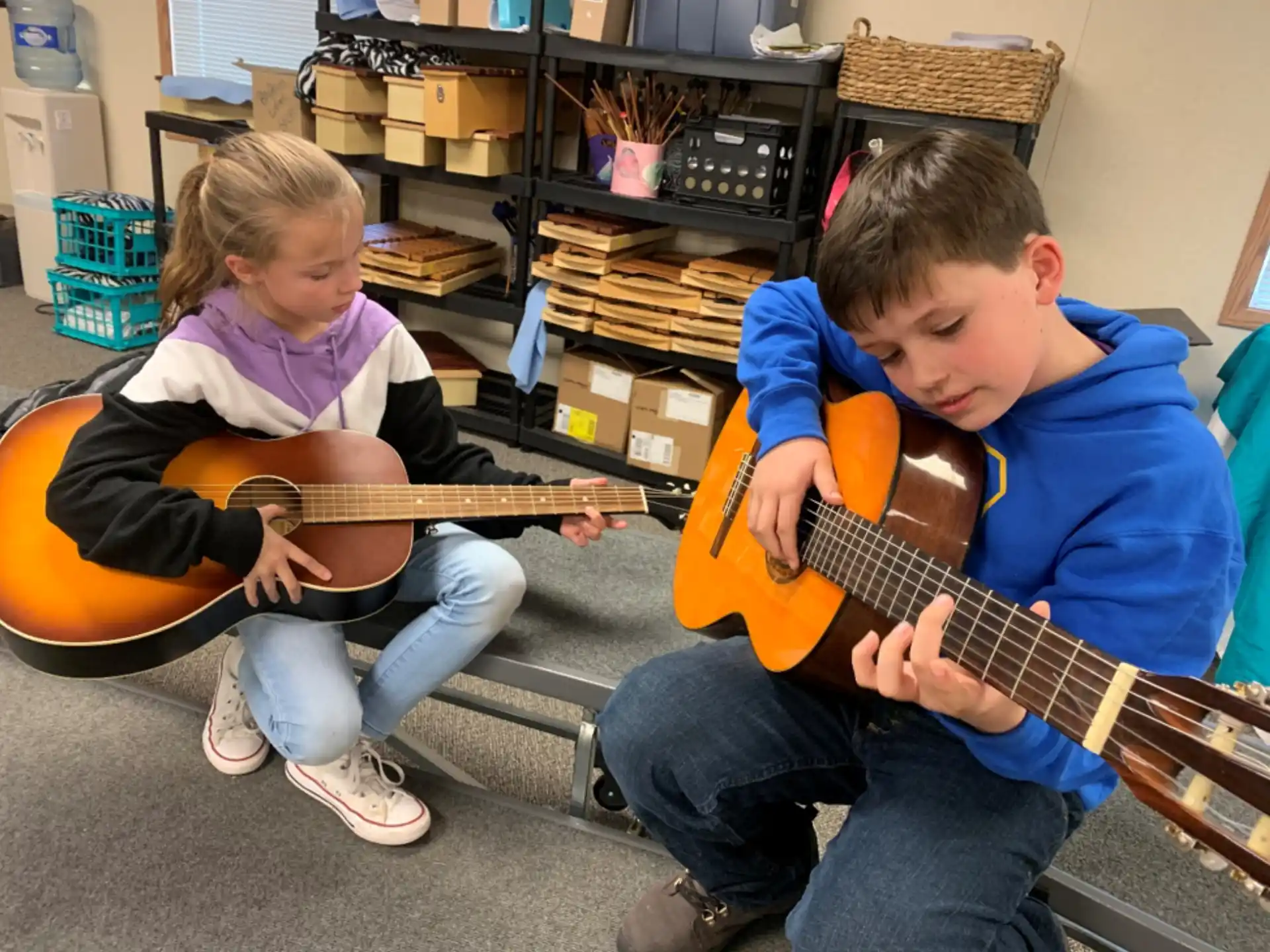 a boy and girl playing guitars