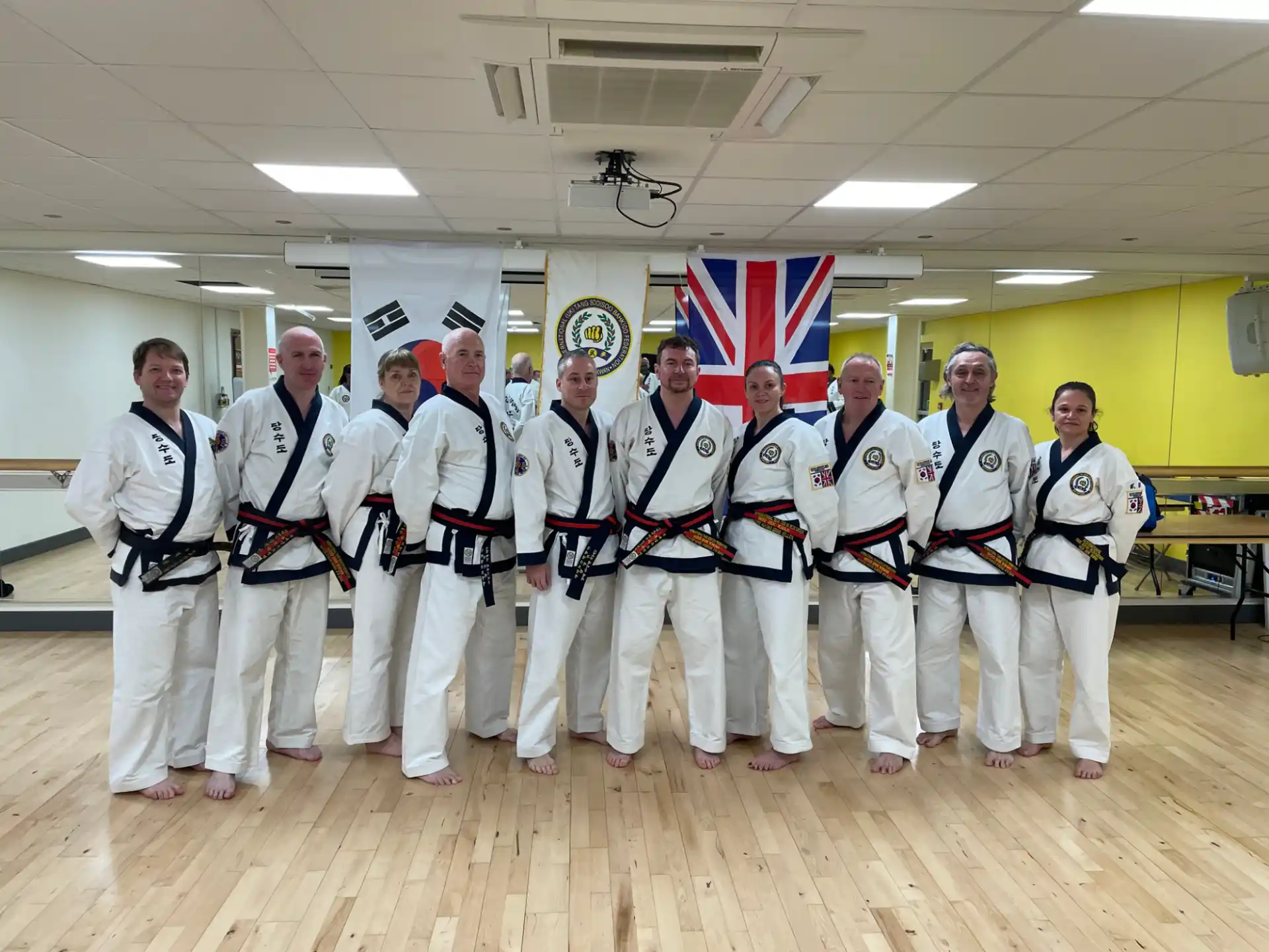 a group of people in white karate uniforms posing for a photo