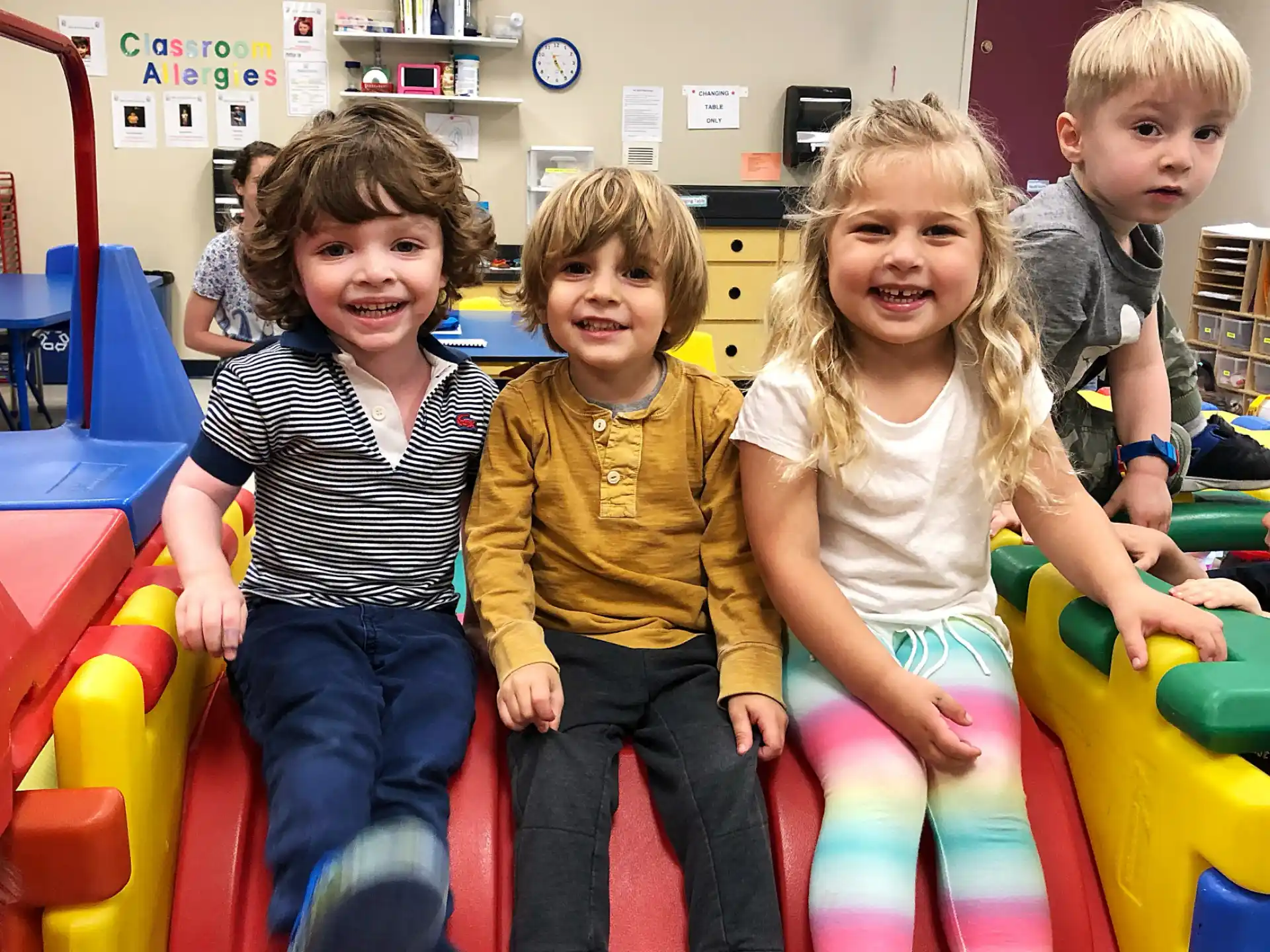 a group of children sitting on a colorful toy