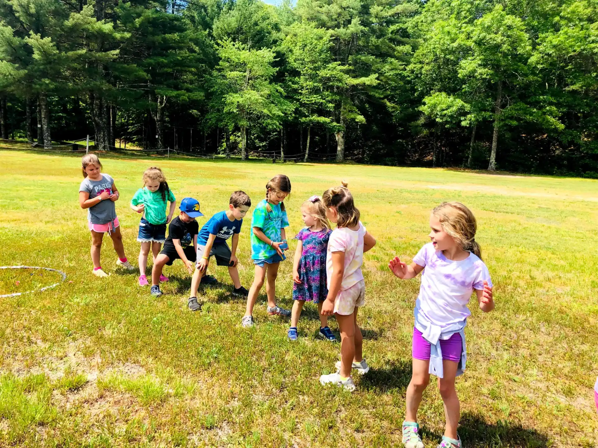 a group of children running on a grass field