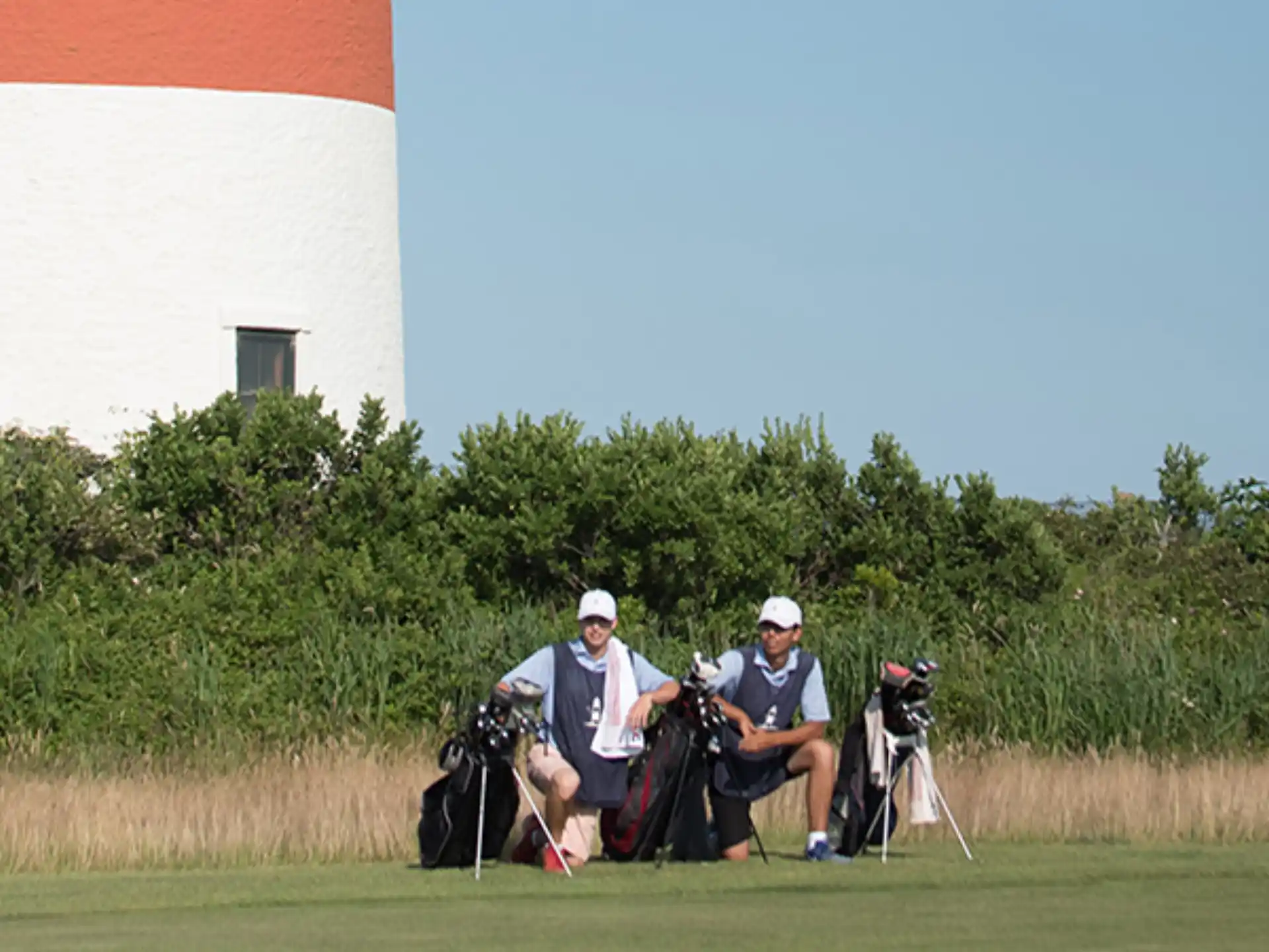 a couple of men sitting on a golf cart in a field