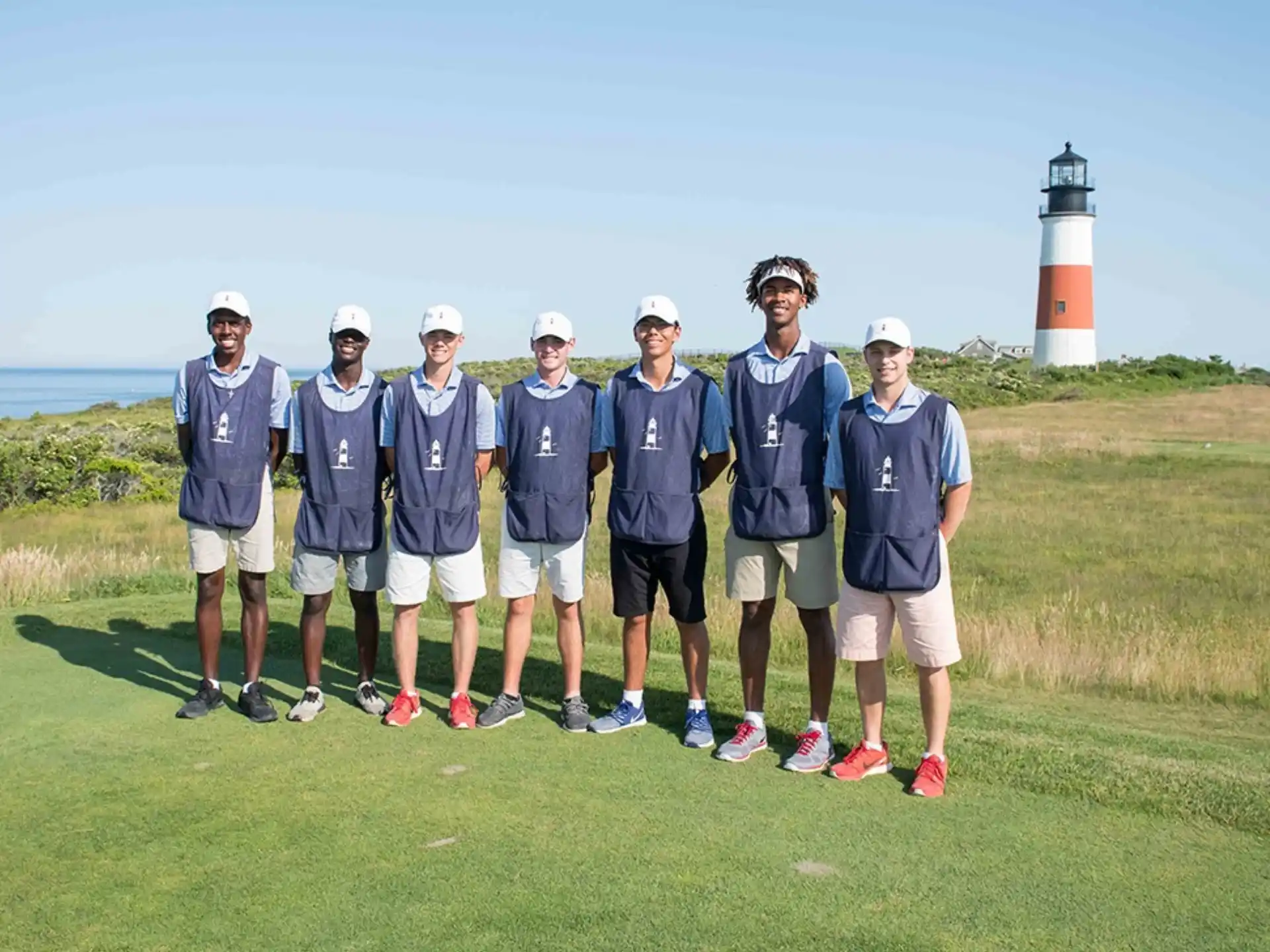 a group of men in blue shirts standing on a golf course