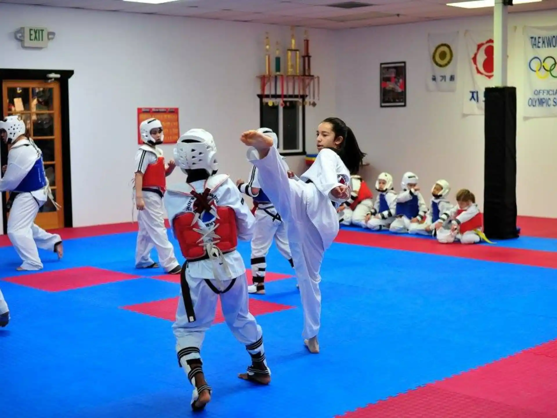 a woman and a man in a karate uniform with a group of people in the background