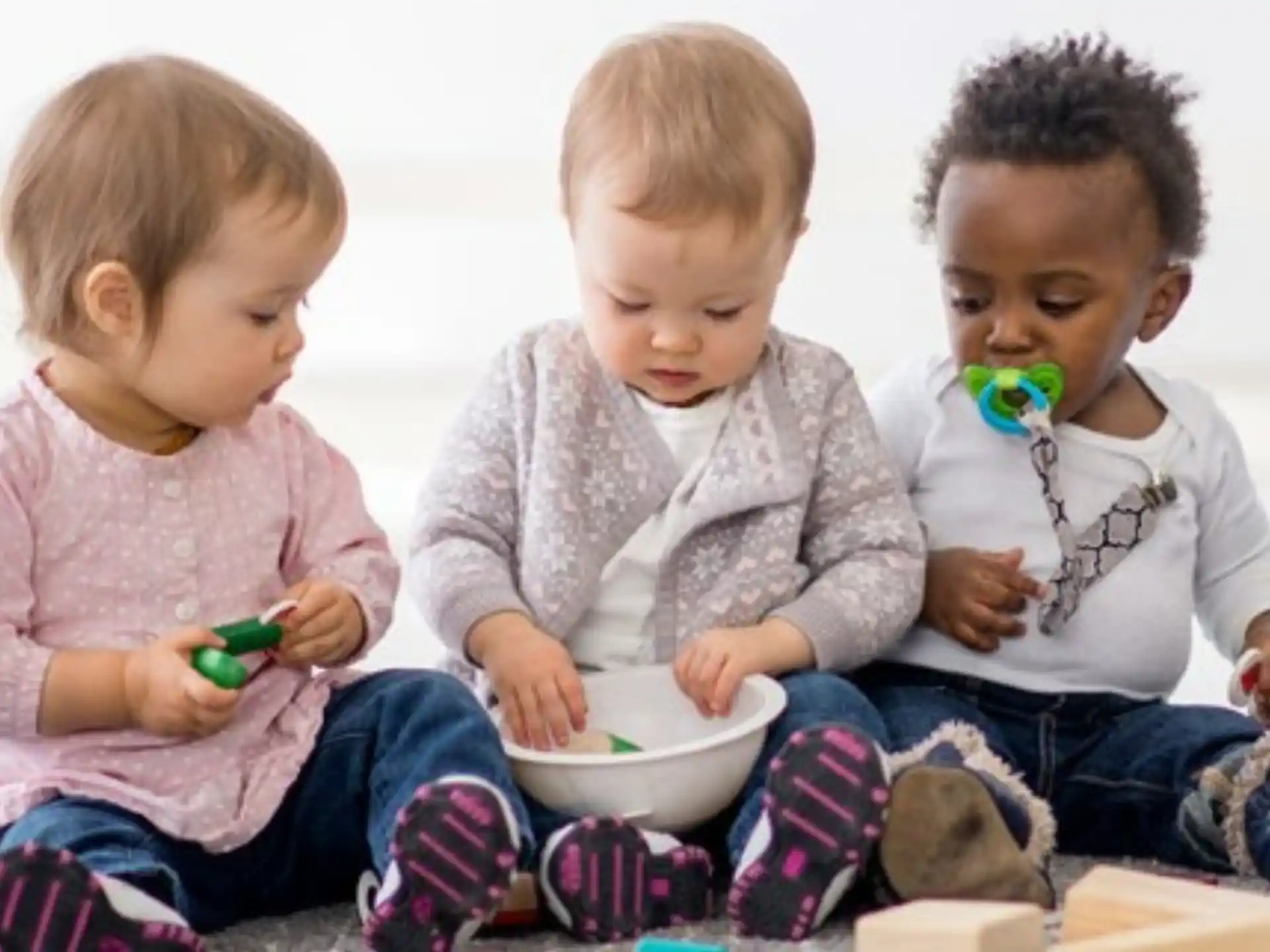 a group of babies eating from a bowl