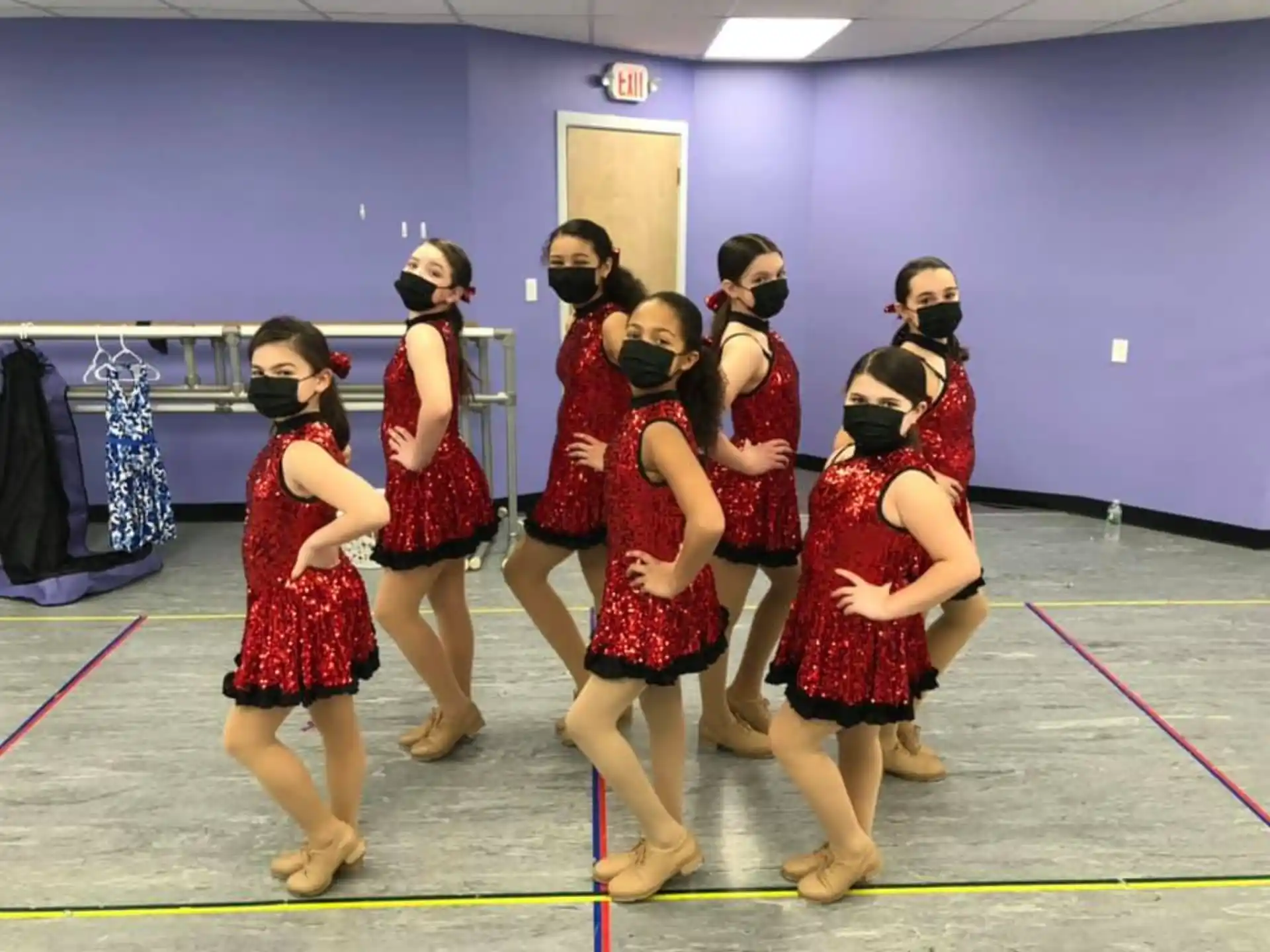 a group of women in red dresses