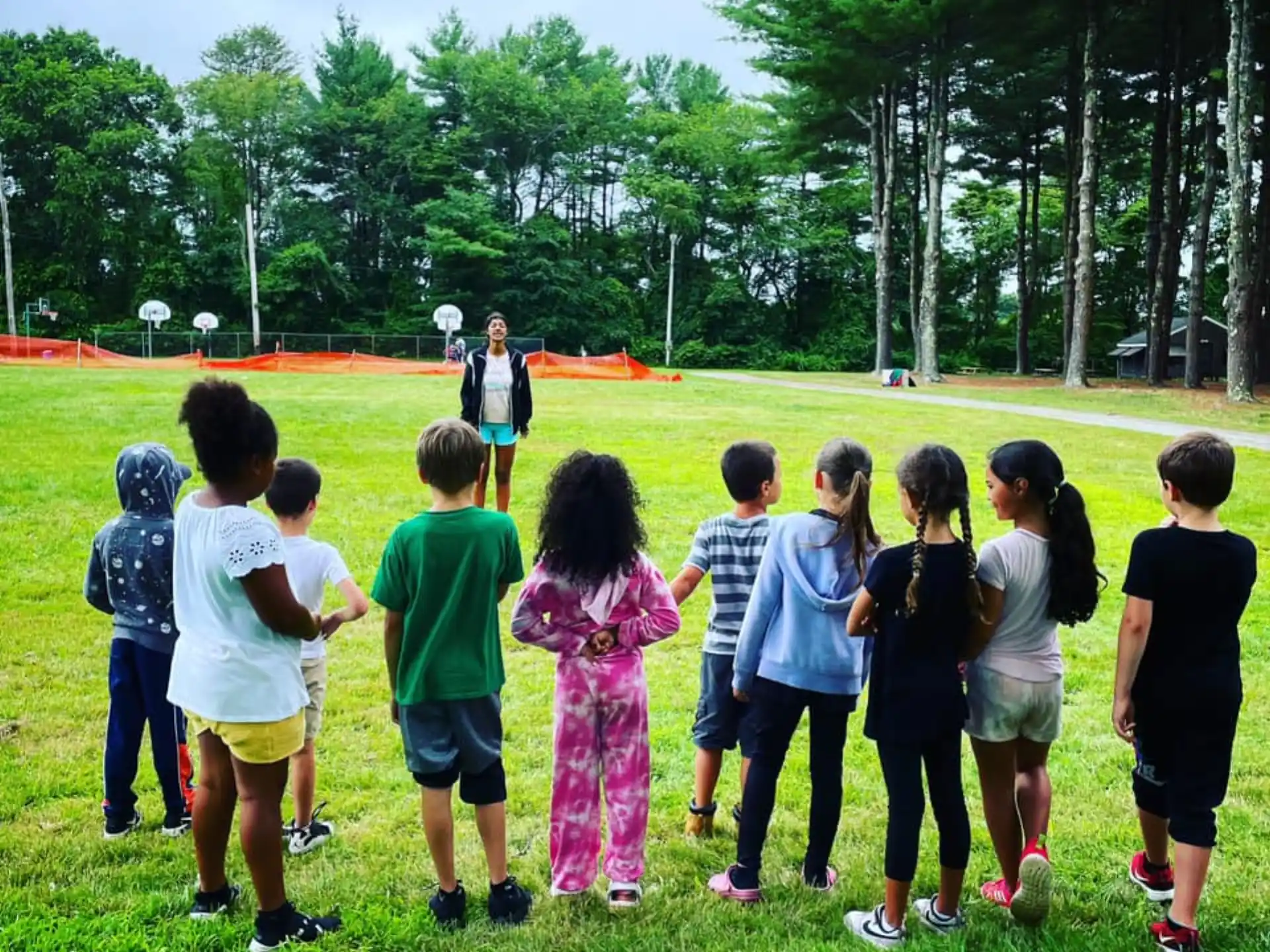a group of children standing on grass