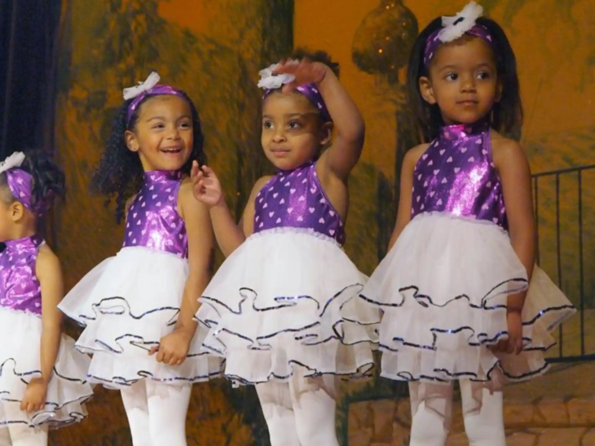 a group of girls wearing cheerleaders and standing on a stage
