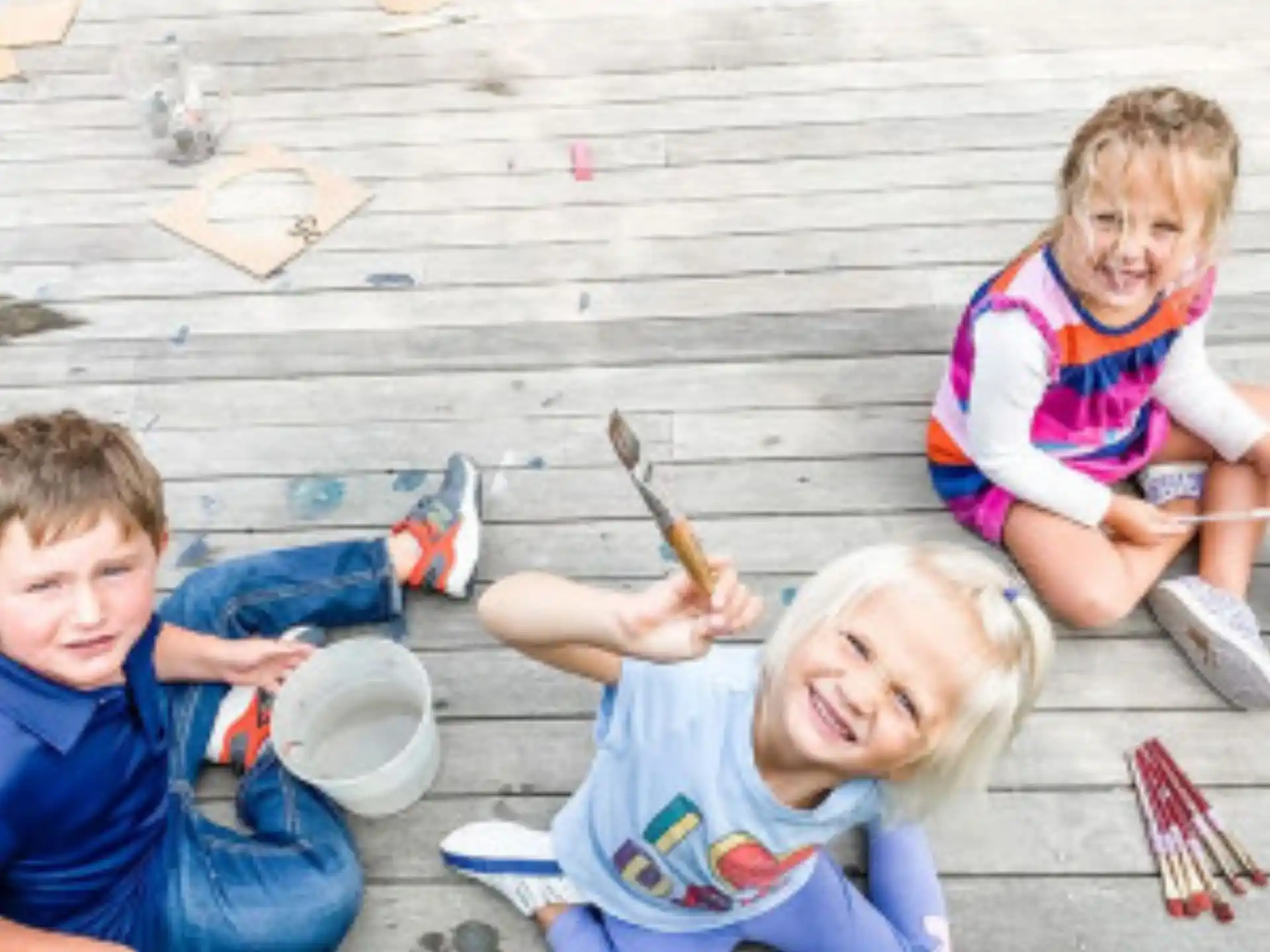 a group of children sitting on the ground playing with a toy