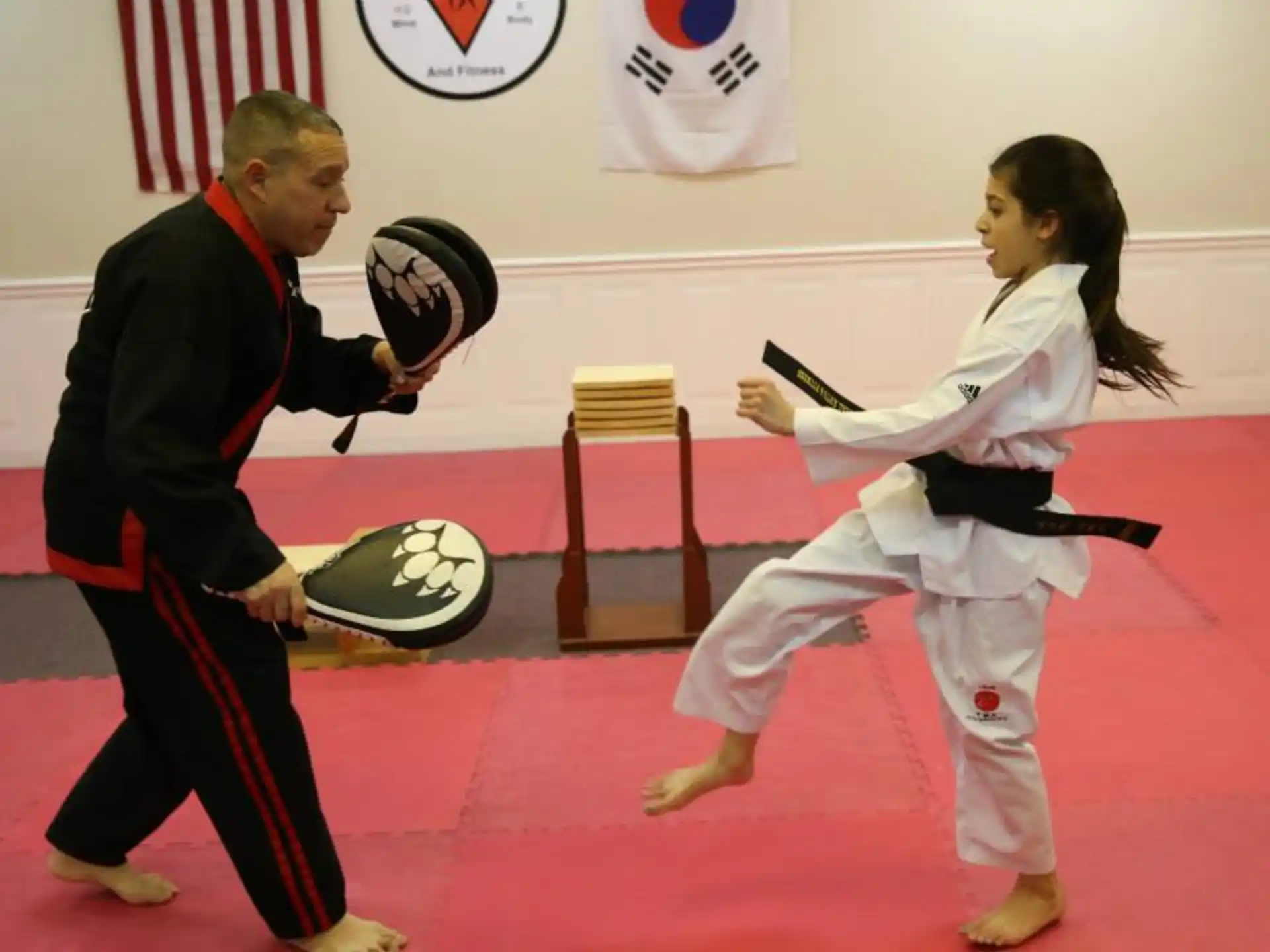 a man and a woman in karate uniforms holding swords