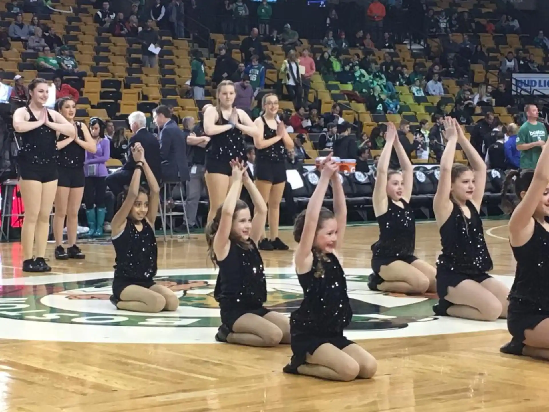 a group of women in black and white uniforms on a wooden floor