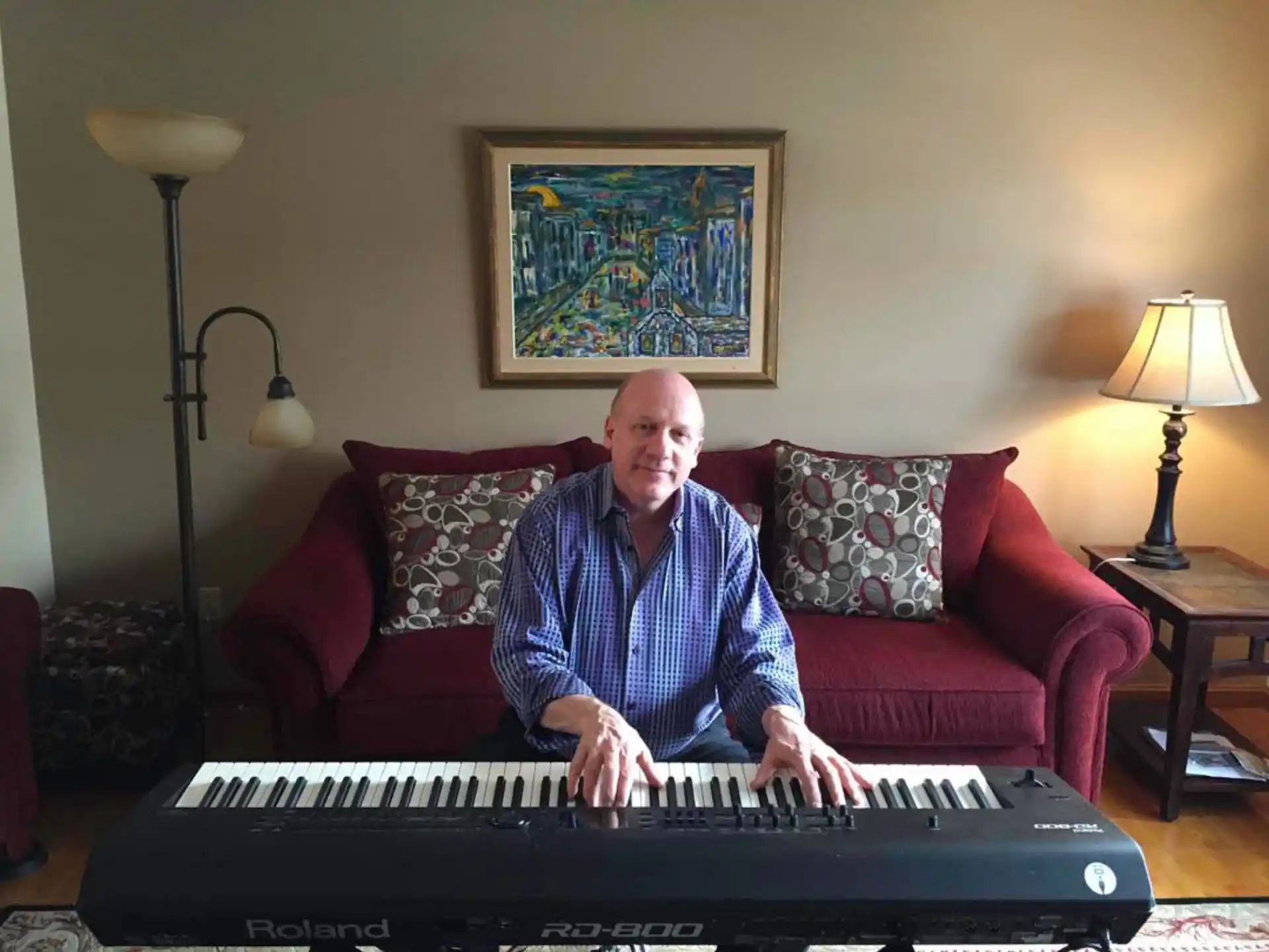 a person sitting on a couch playing a piano