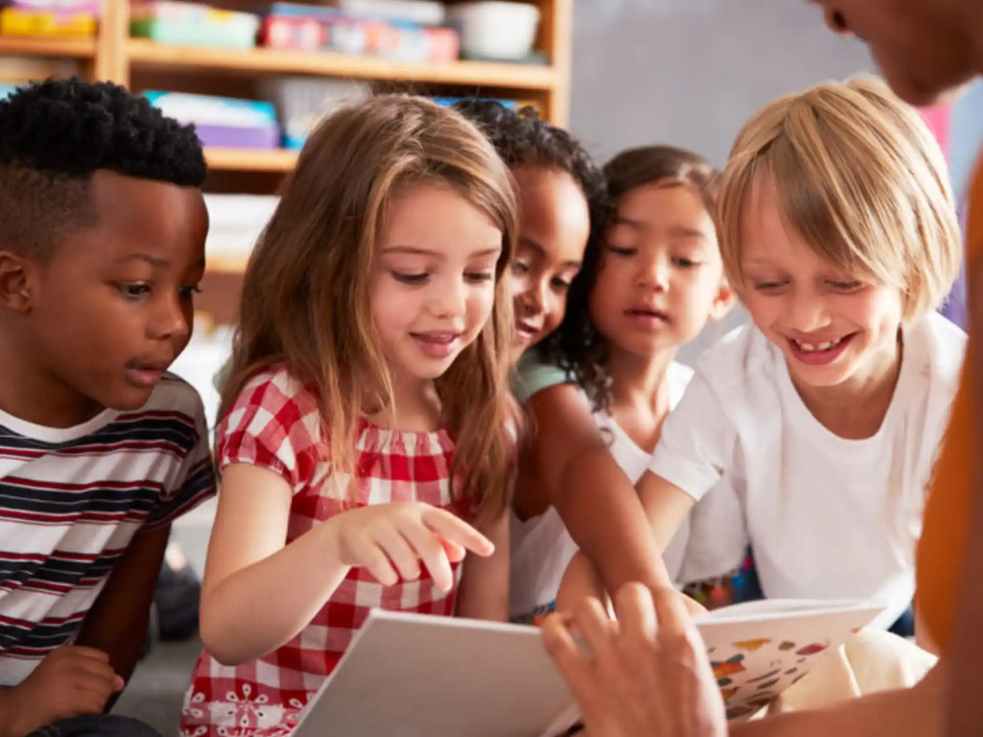 a group of children looking at a book
