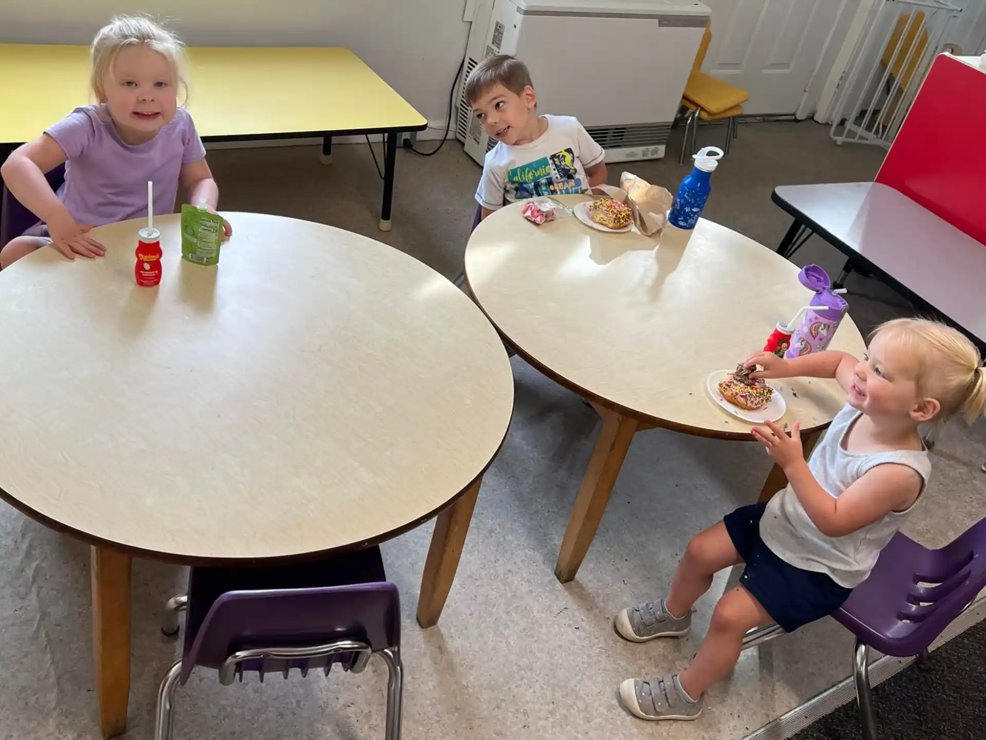 a group of children eating at a table