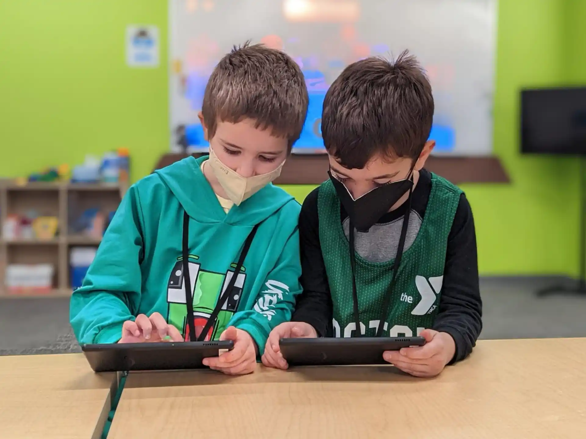 a couple of boys looking at a tablet