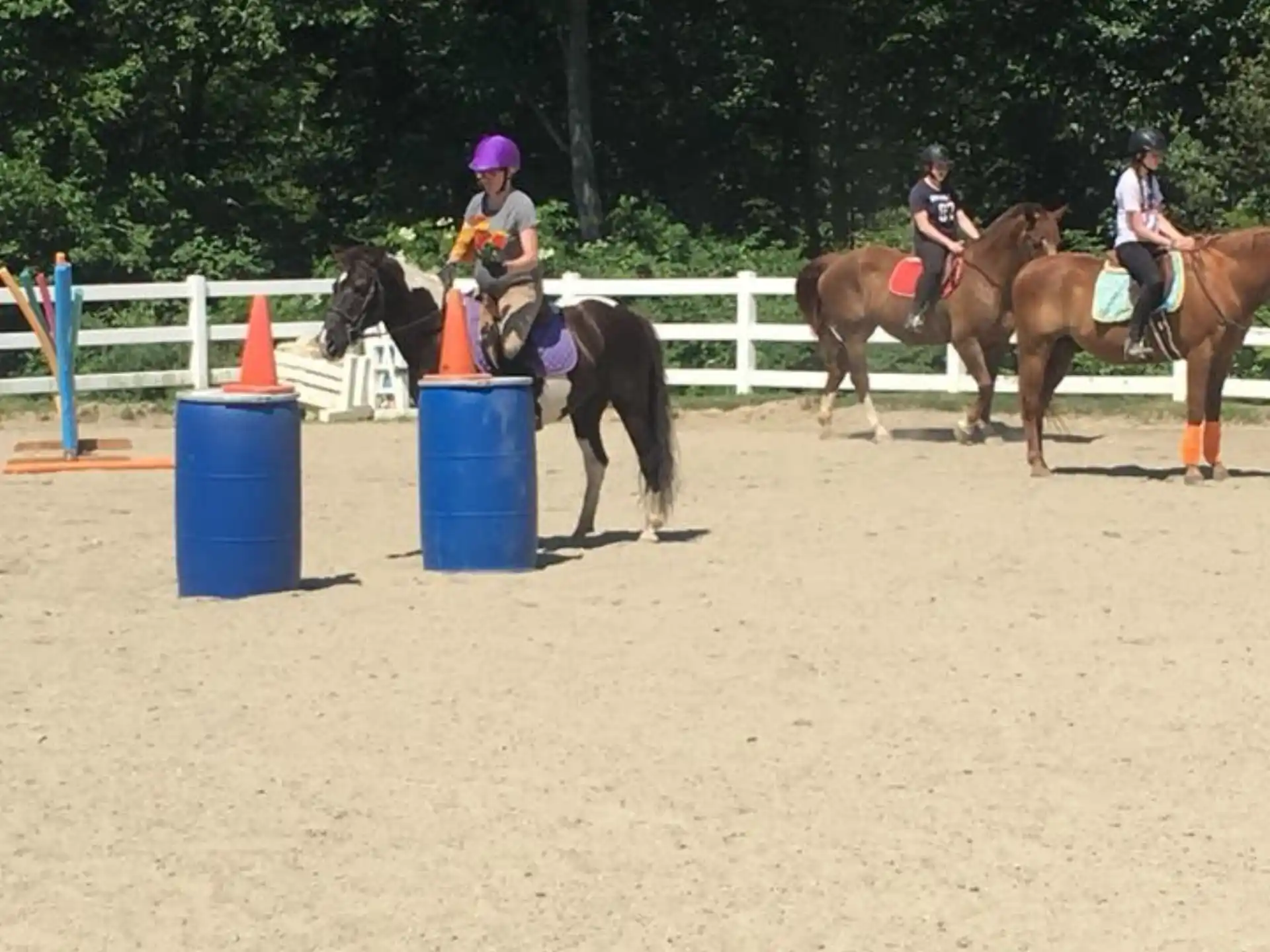 people riding horses in a dirt arena