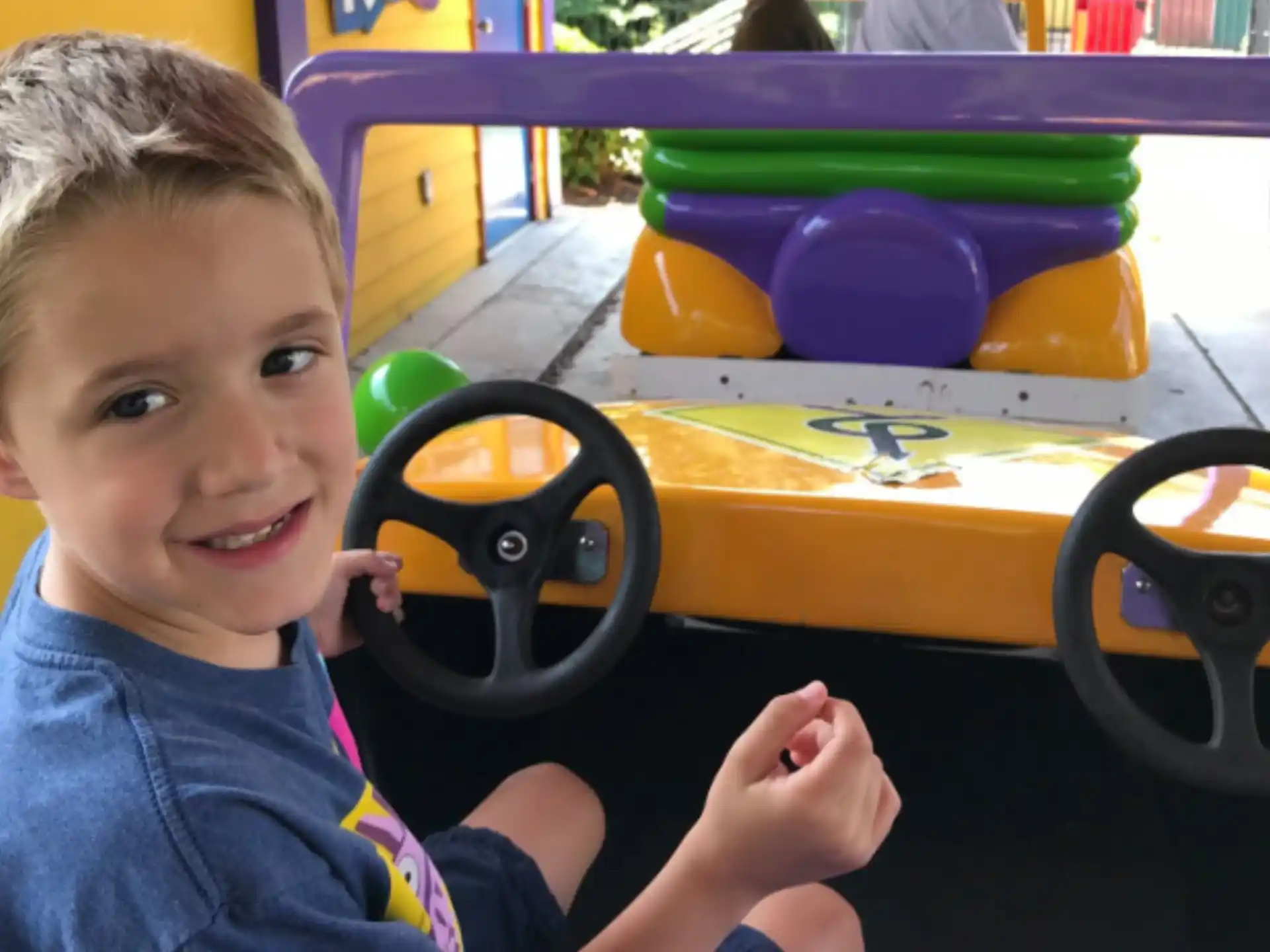 a boy sitting in a toy car
