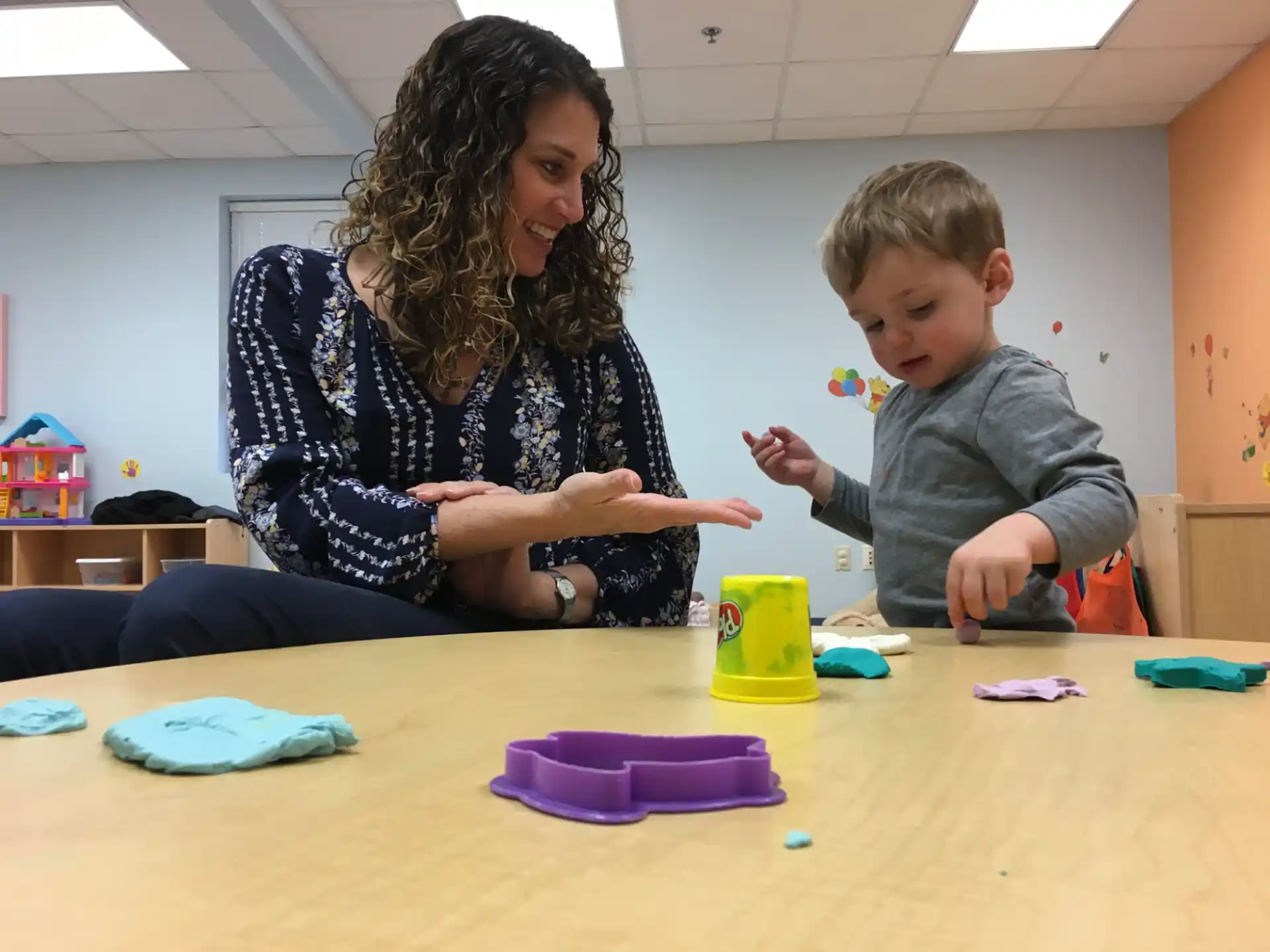 a person and a child playing with toys on a table