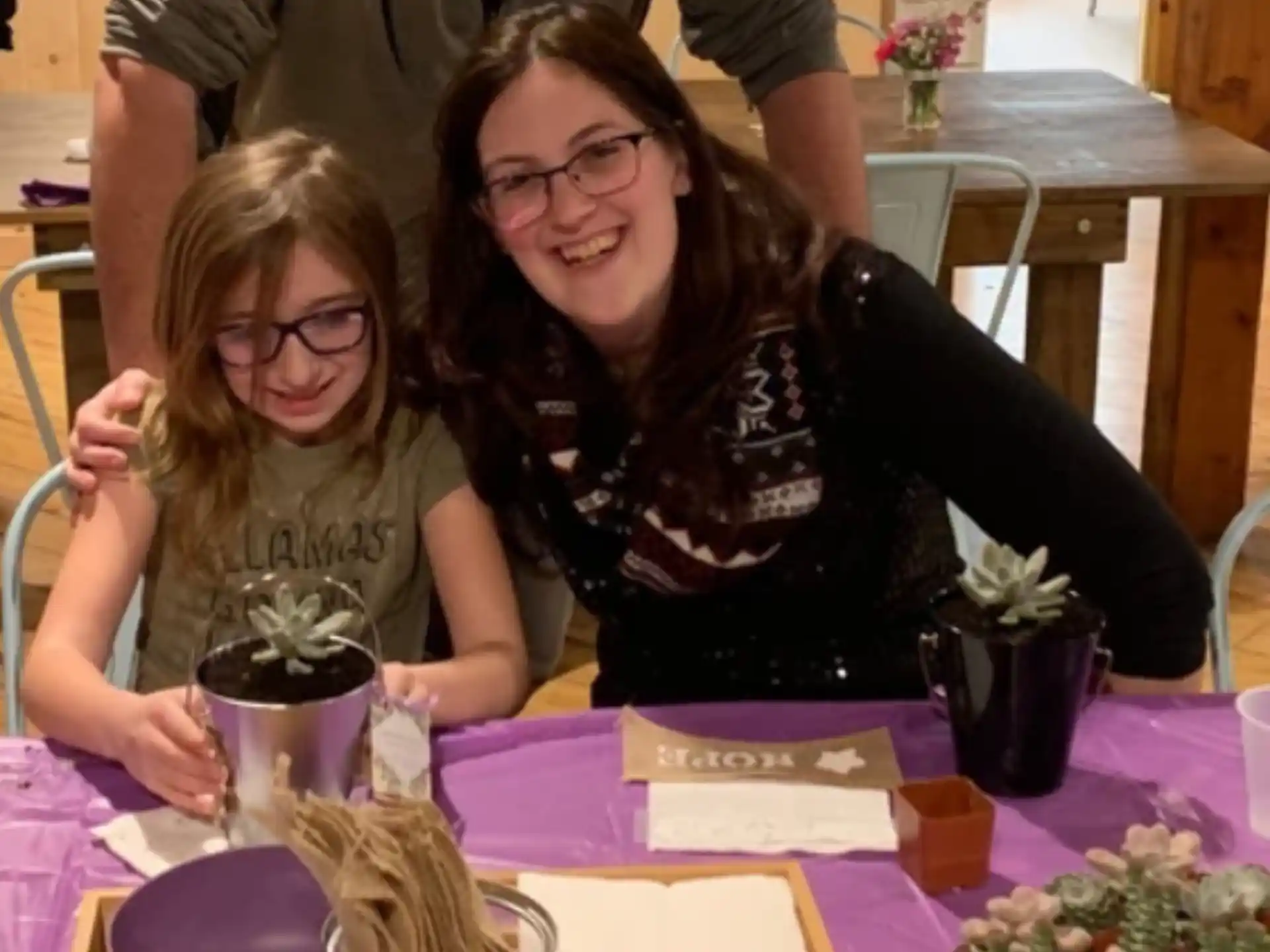 a person and a girl sitting at a table
