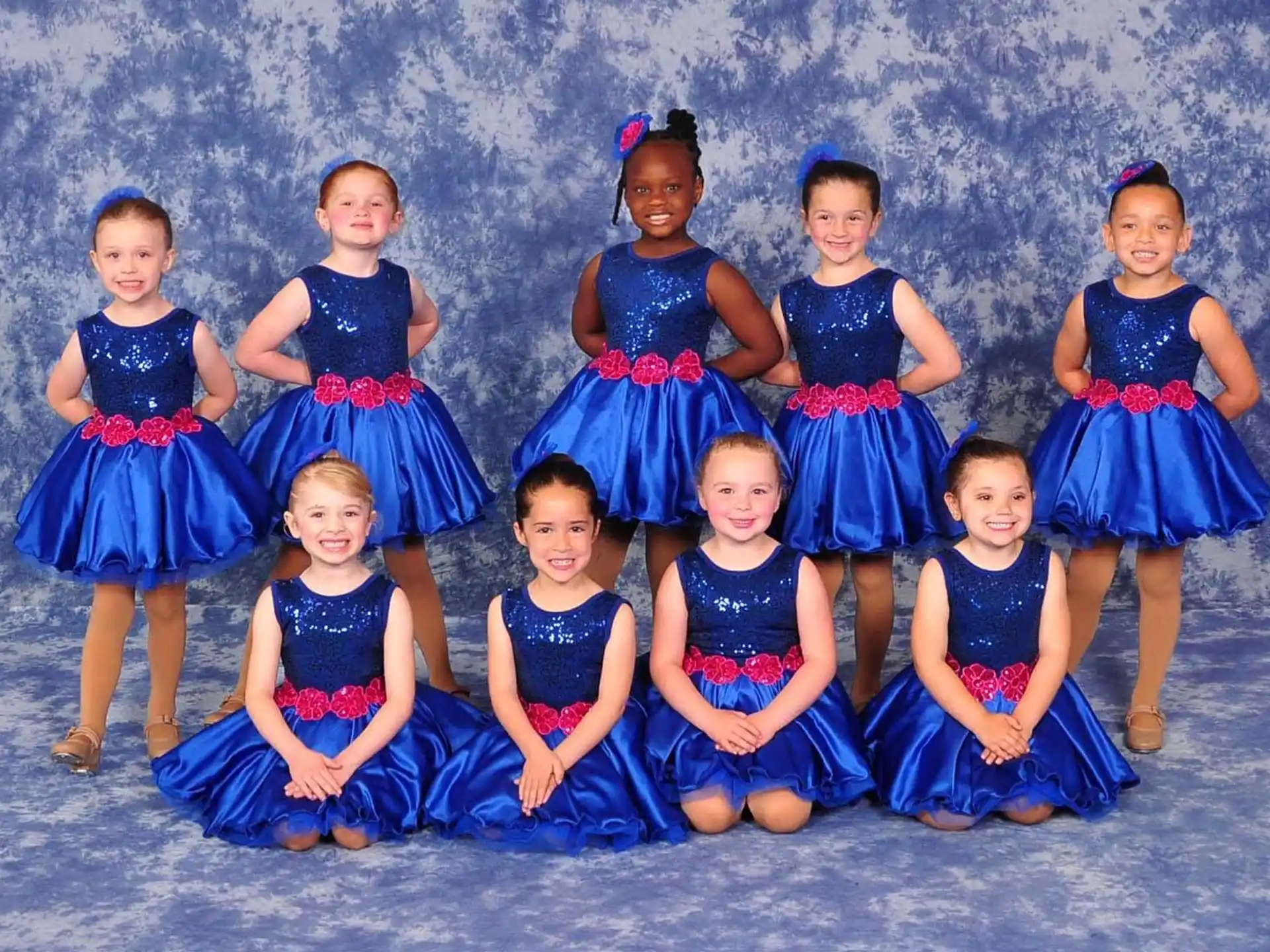 a group of girls in blue dresses