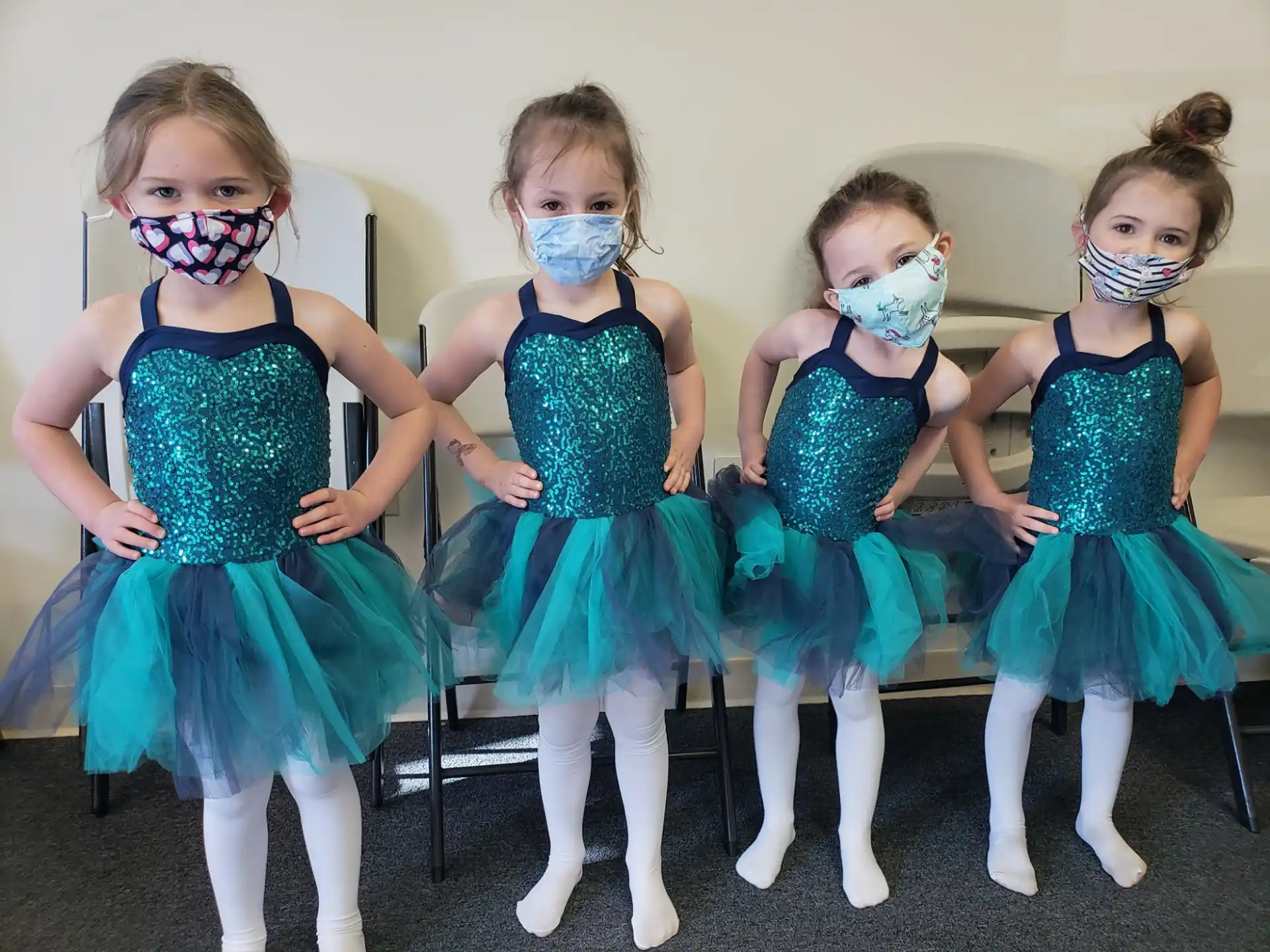 a group of girls wearing blue dresses and white masks