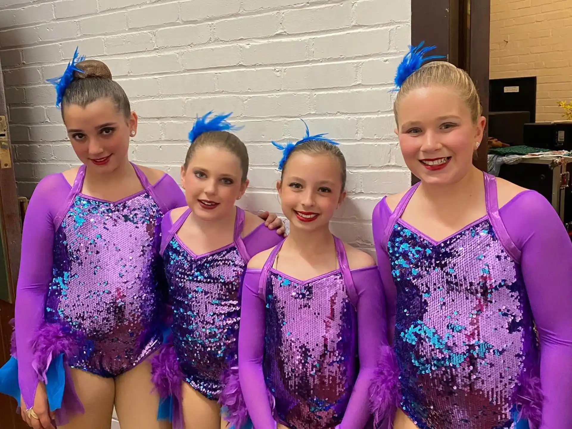 a group of girls in purple dresses