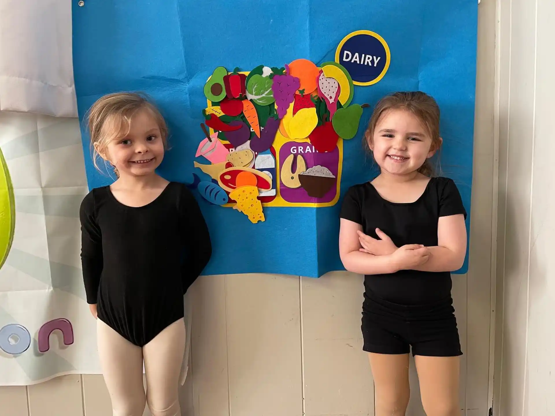 two girls standing in front of a painting