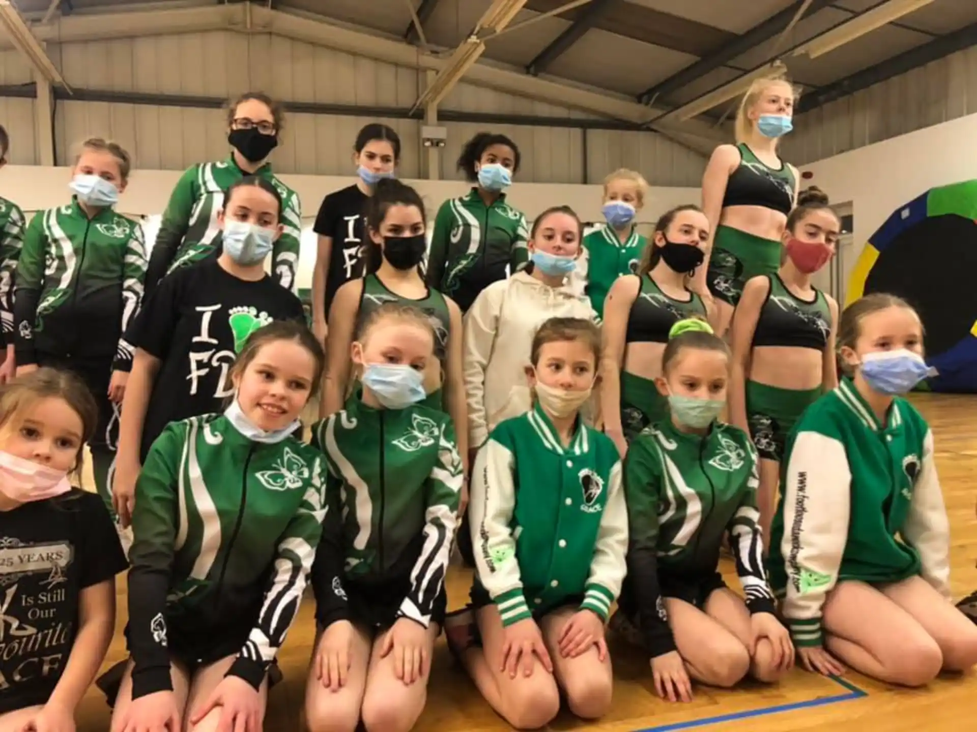 a group of people wearing green and white uniforms posing for a photo
