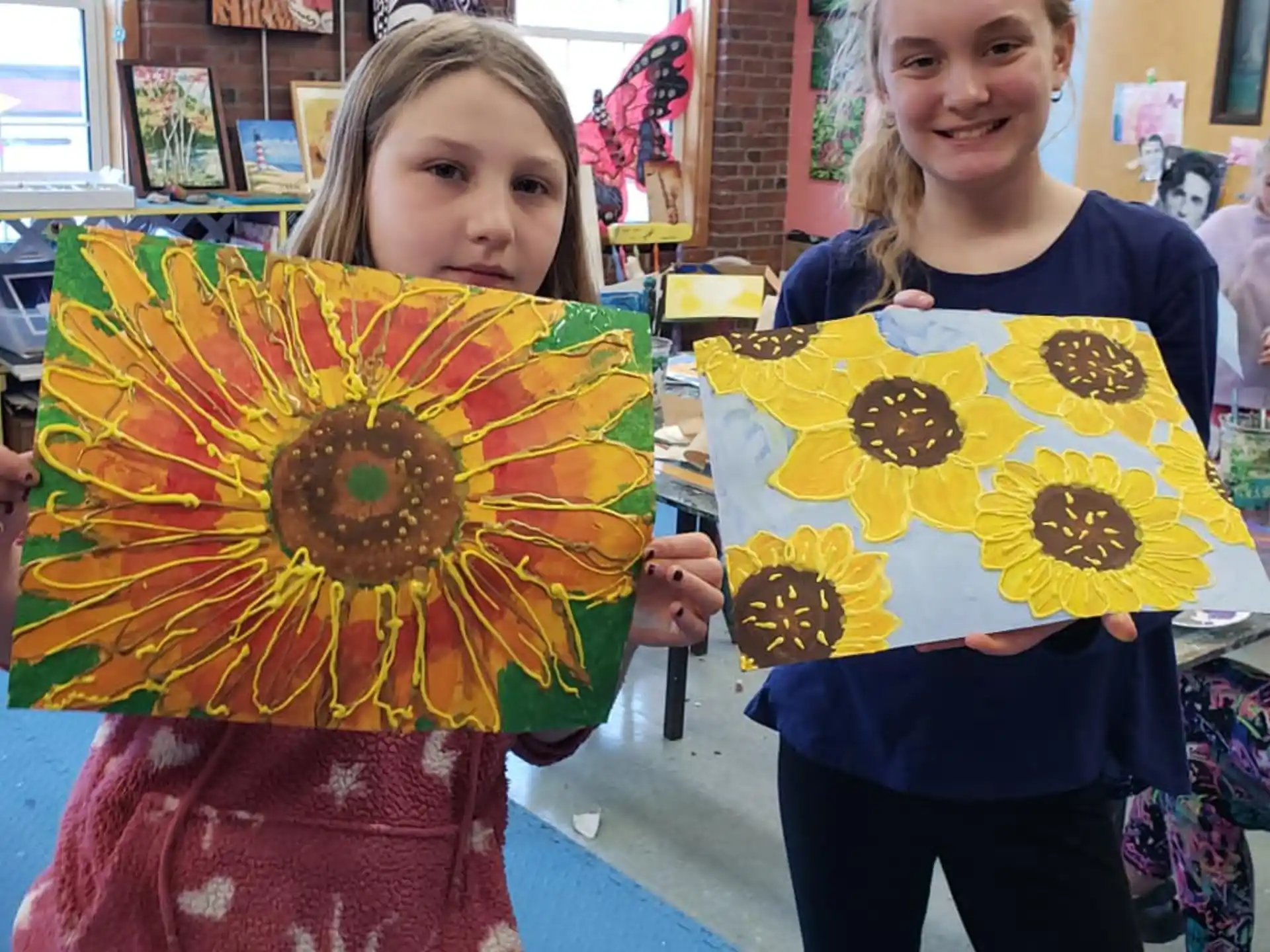 a couple of girls holding up yellow and red paper bags