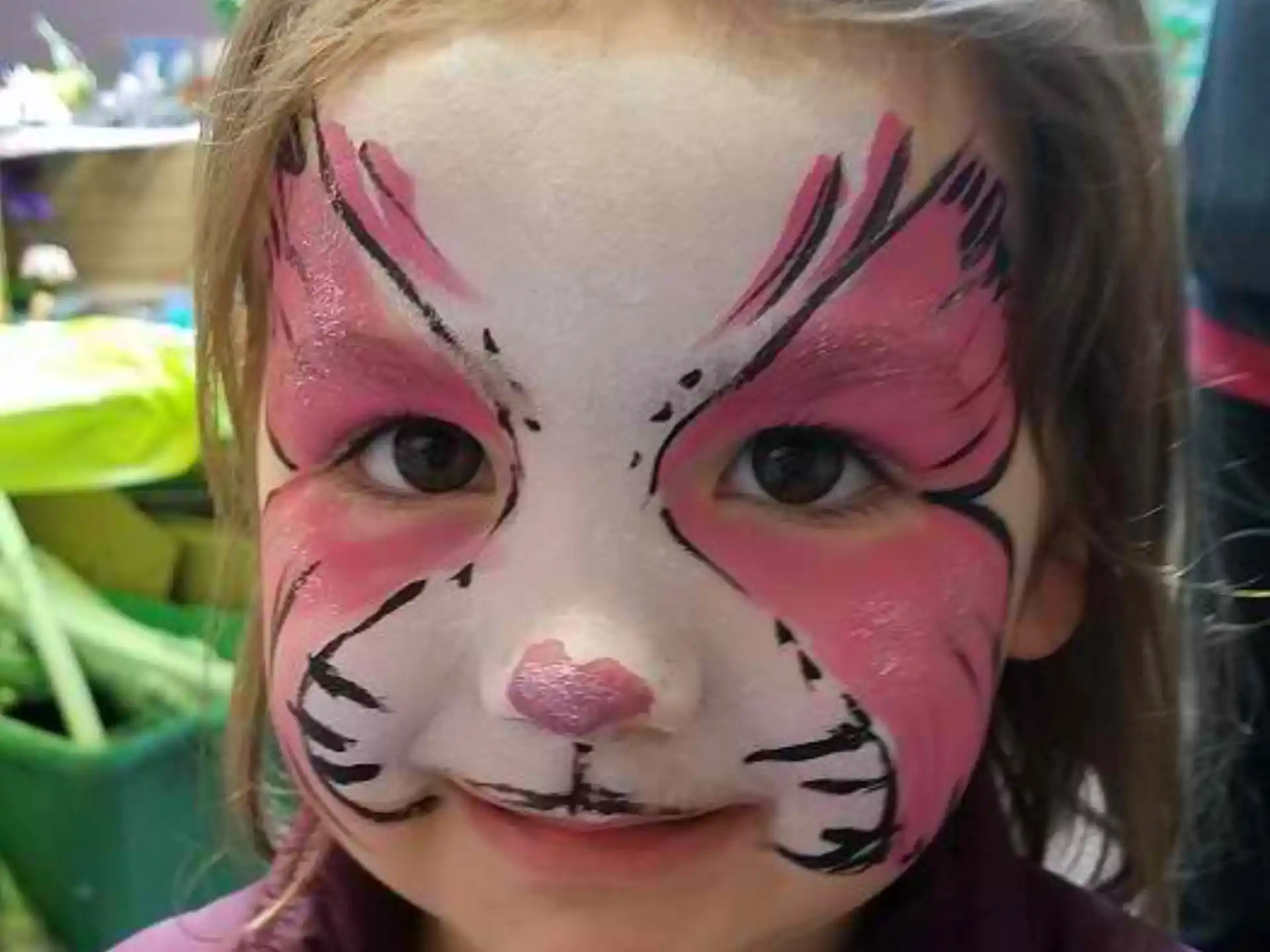 a girl with pink paint on her face