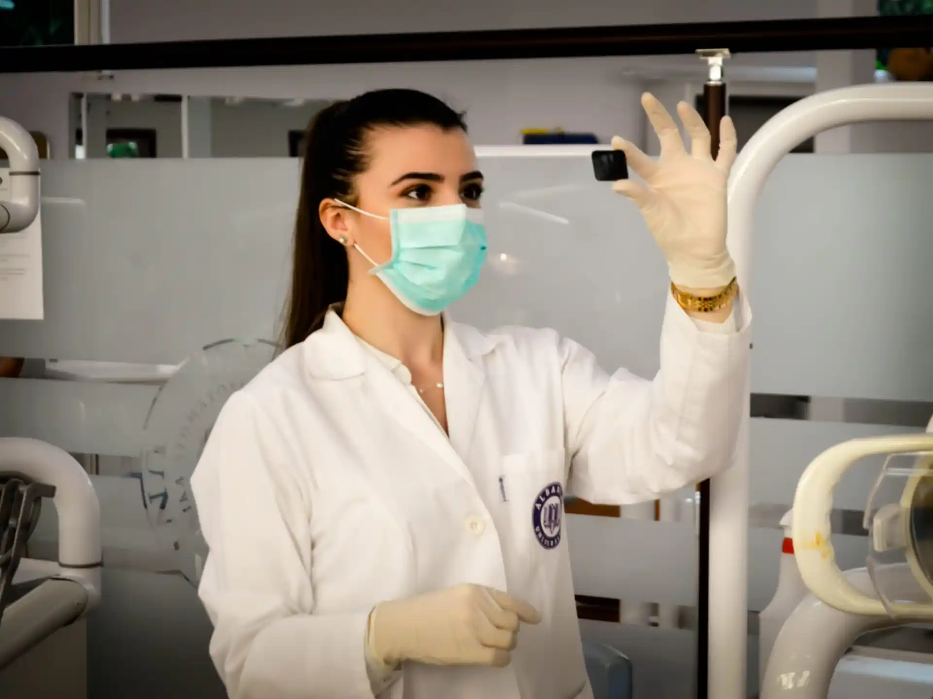 a person in a white coat and mask with a blue face mask