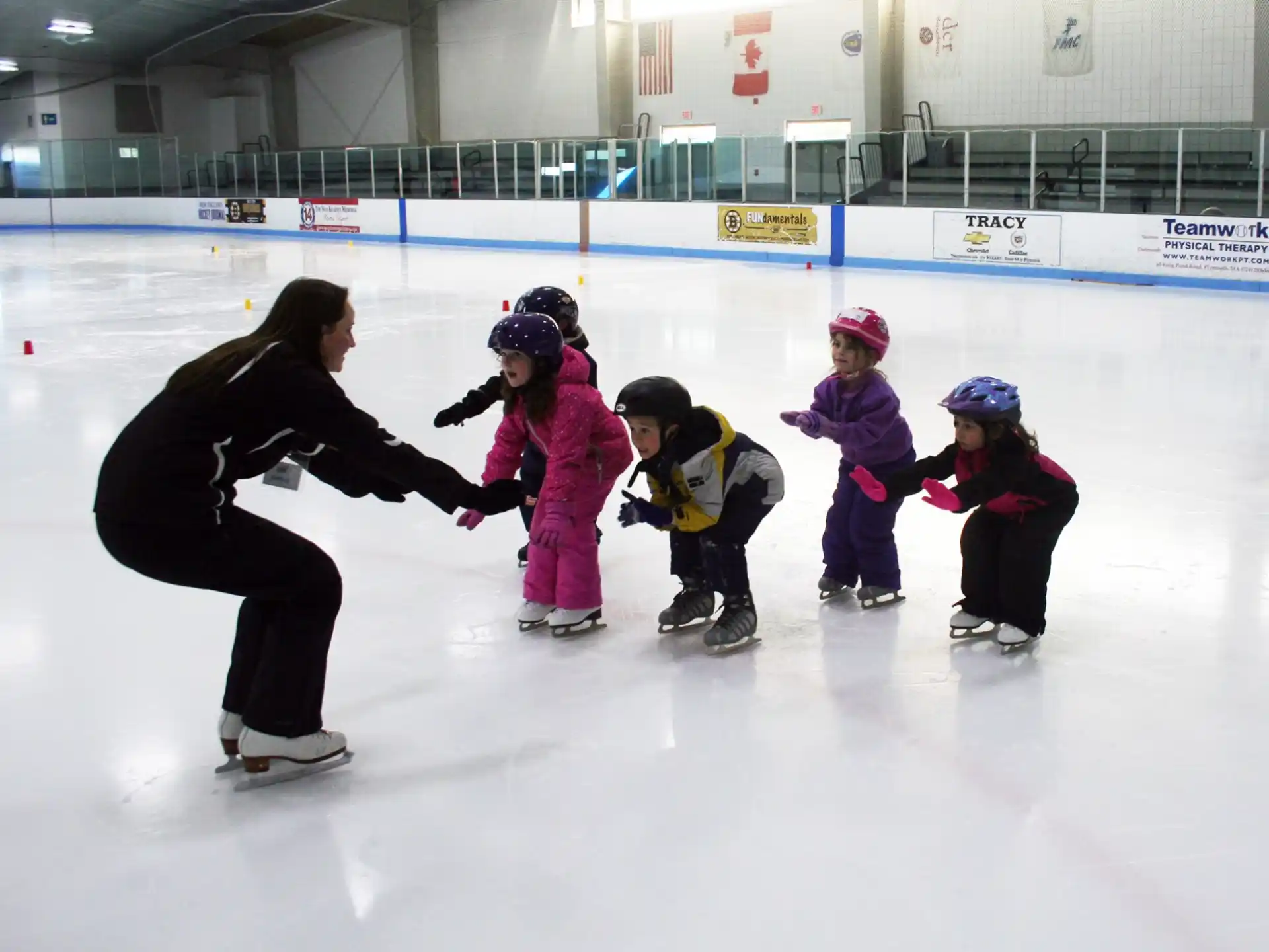 a person and kids on an ice rink