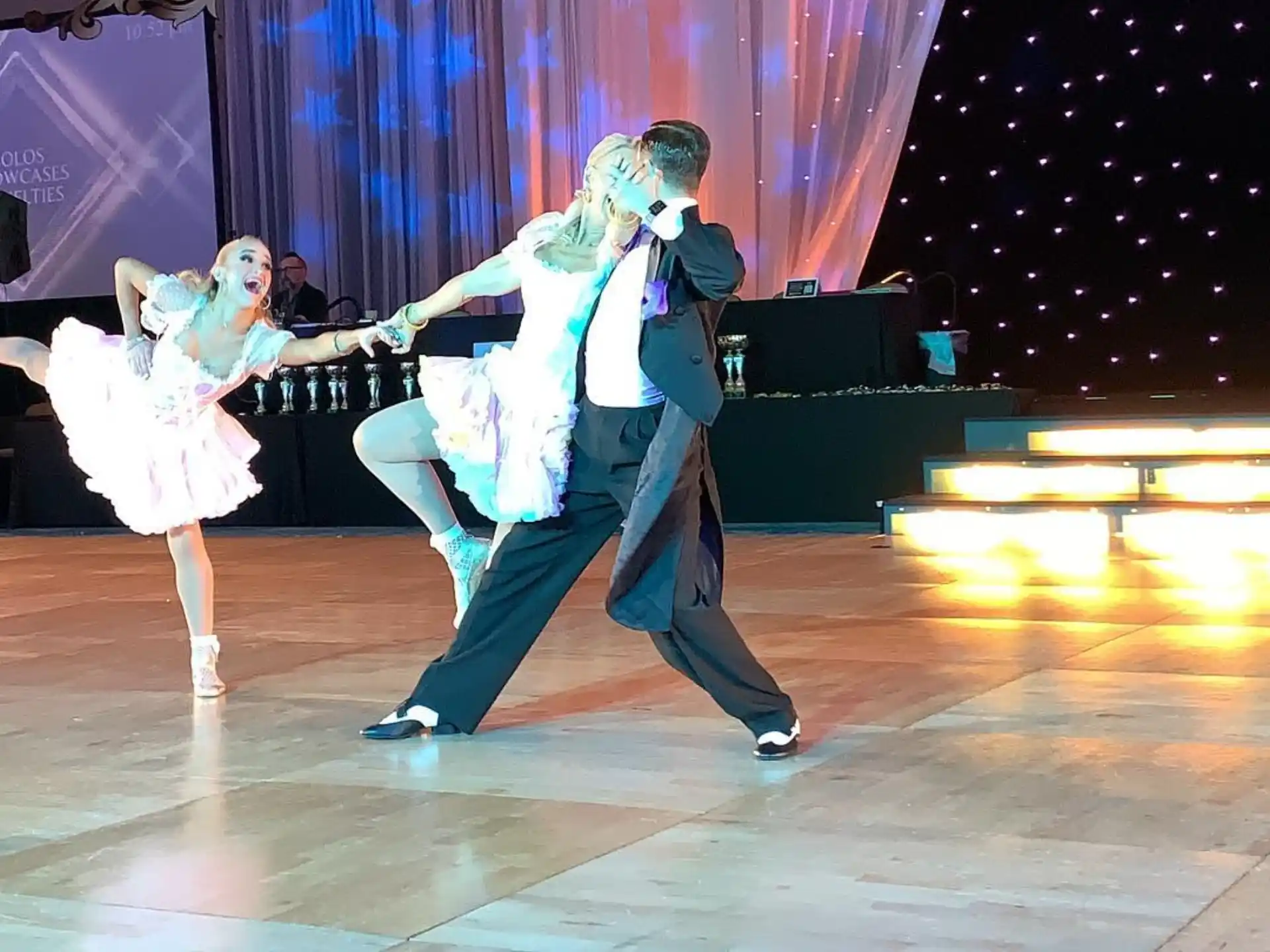 a man and woman dancing on a stage