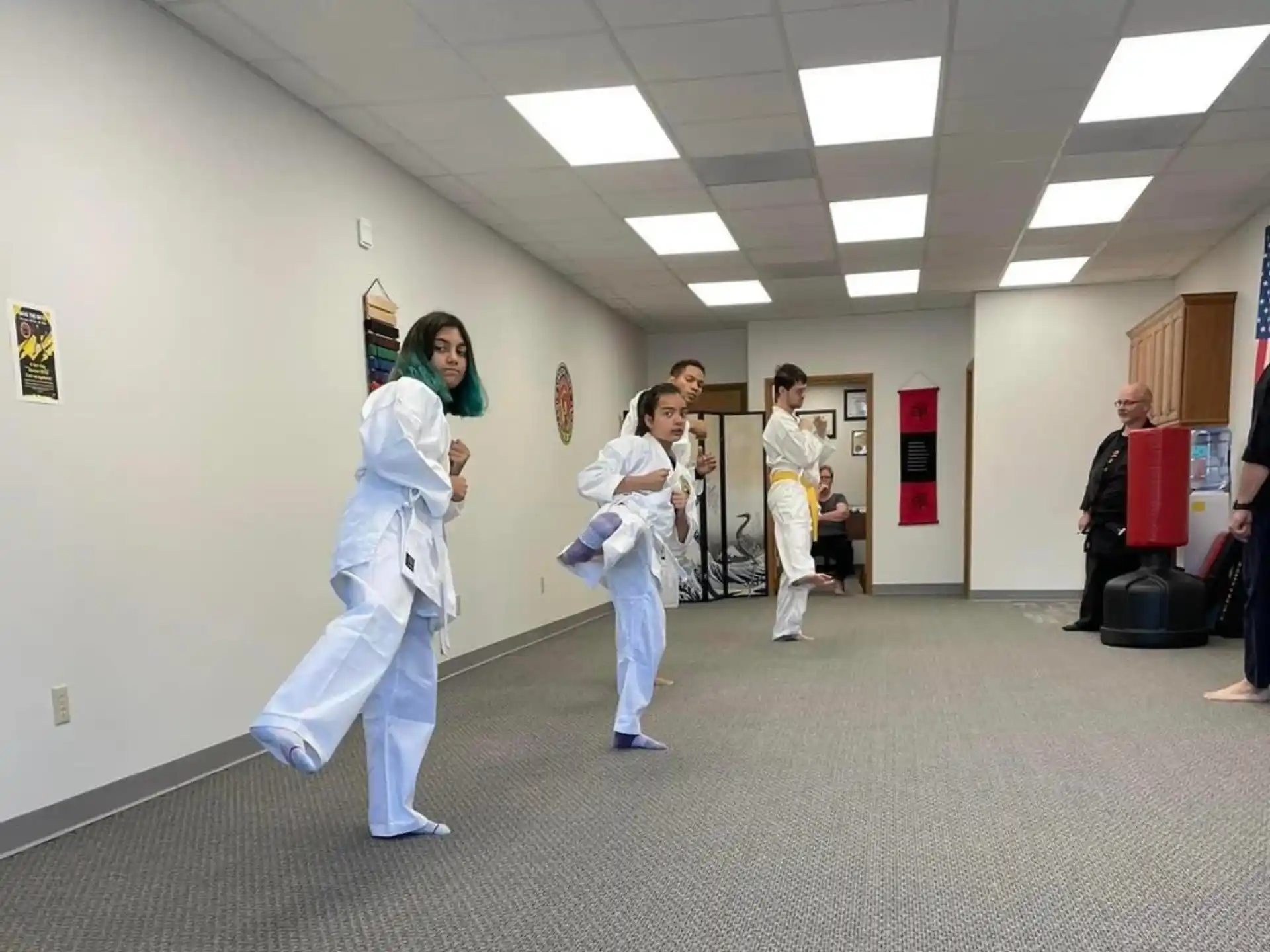a group of people in white karate uniforms in a hallway
