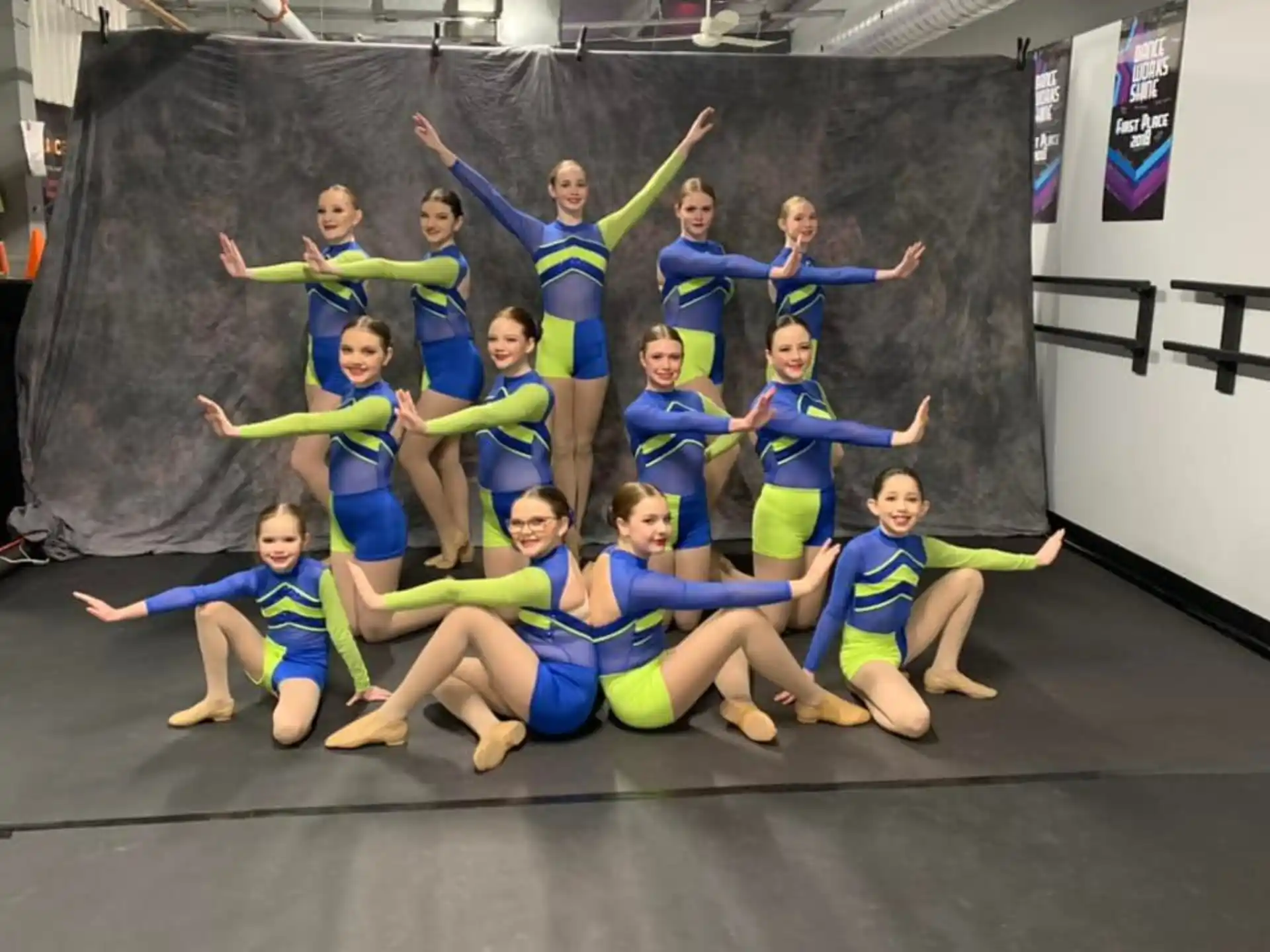 a group of girls in blue and yellow uniforms posing for a photo
