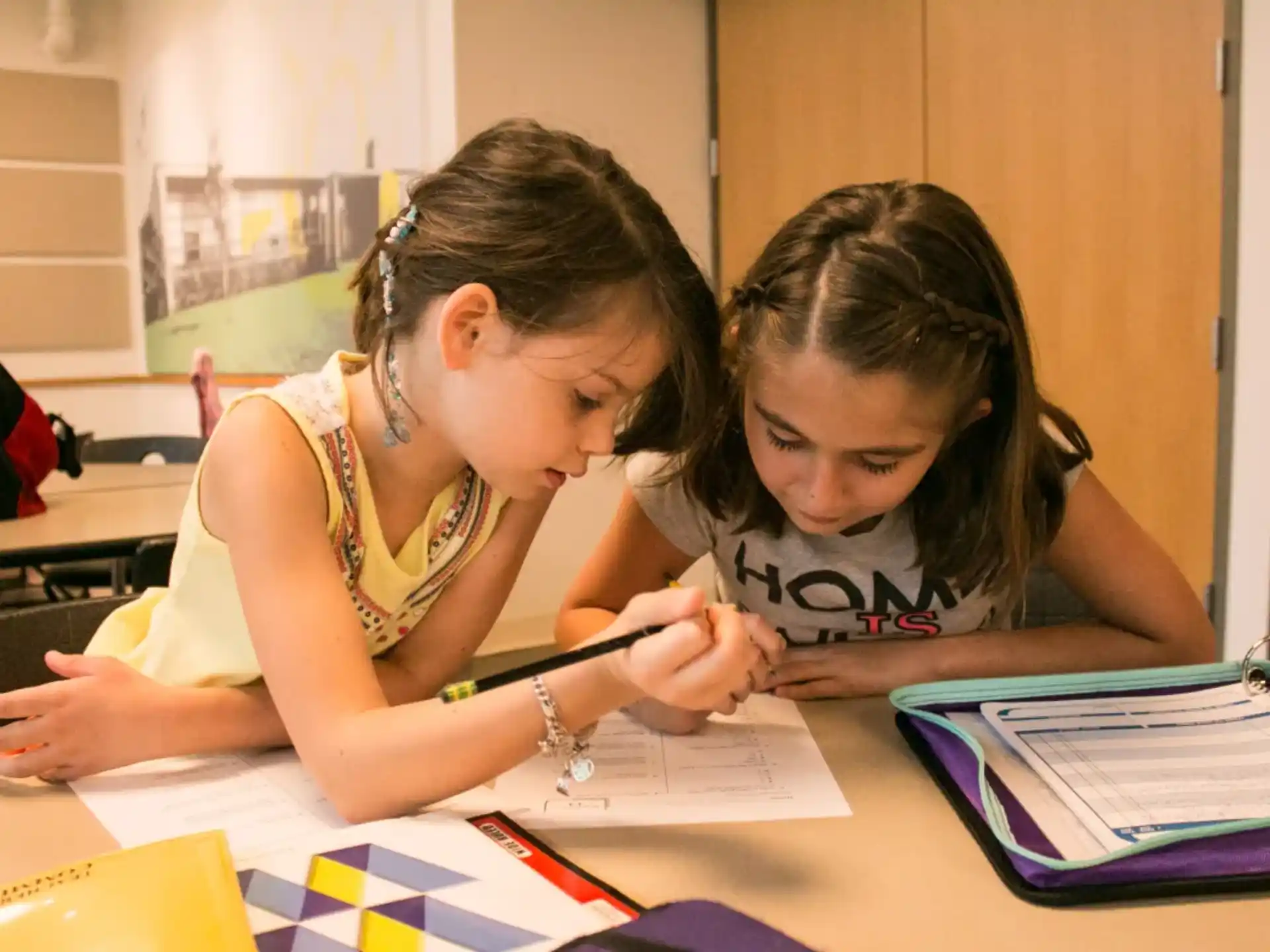 a woman and a girl writing on paper