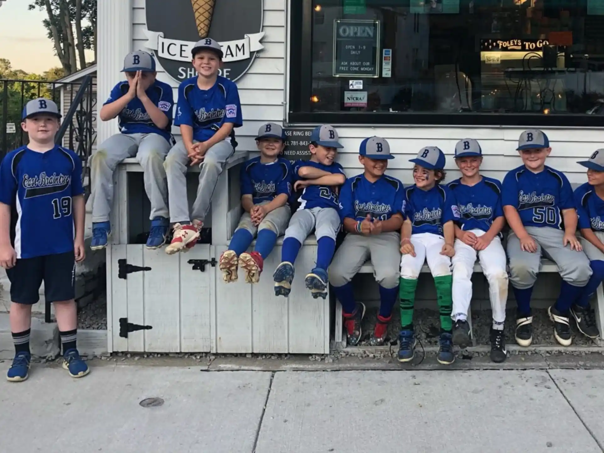 a group of people wearing matching blue uniforms sitting on a bench