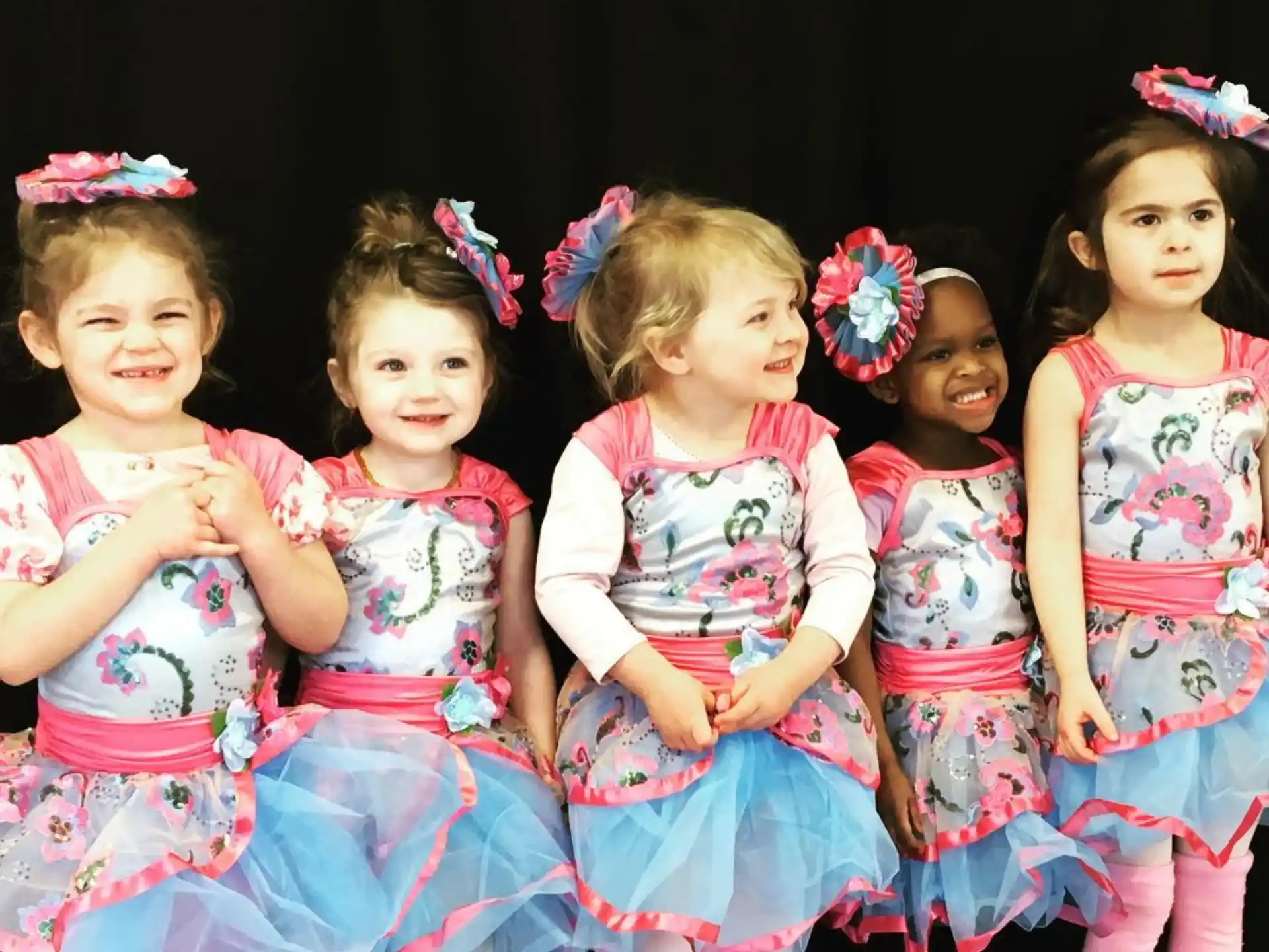a group of girls in dresses
