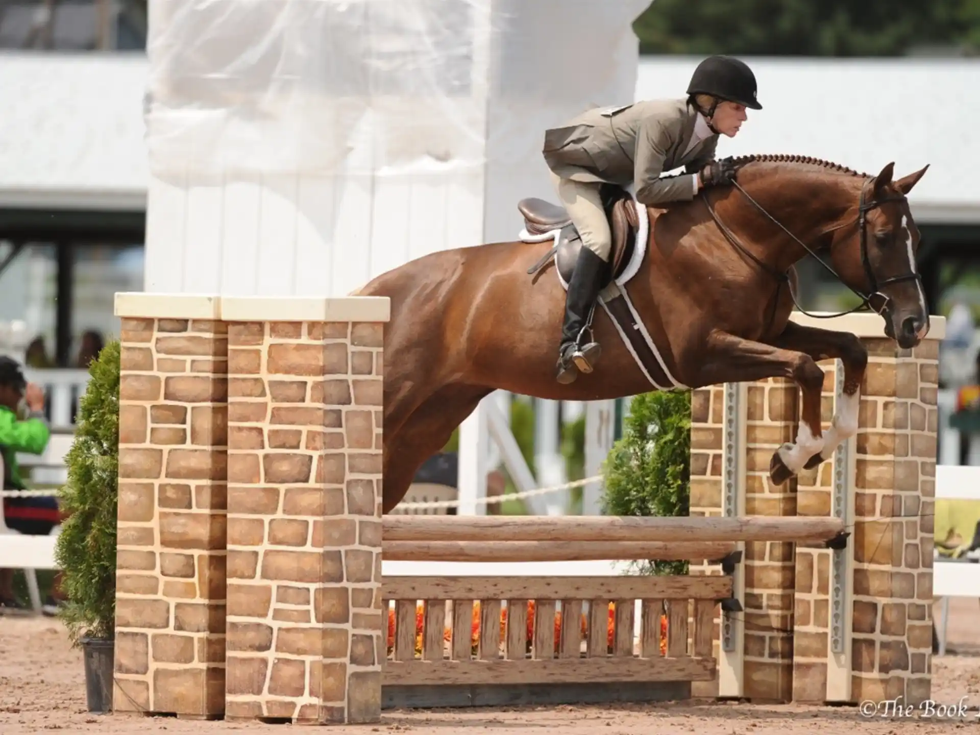 a person jumping a horse over a fence